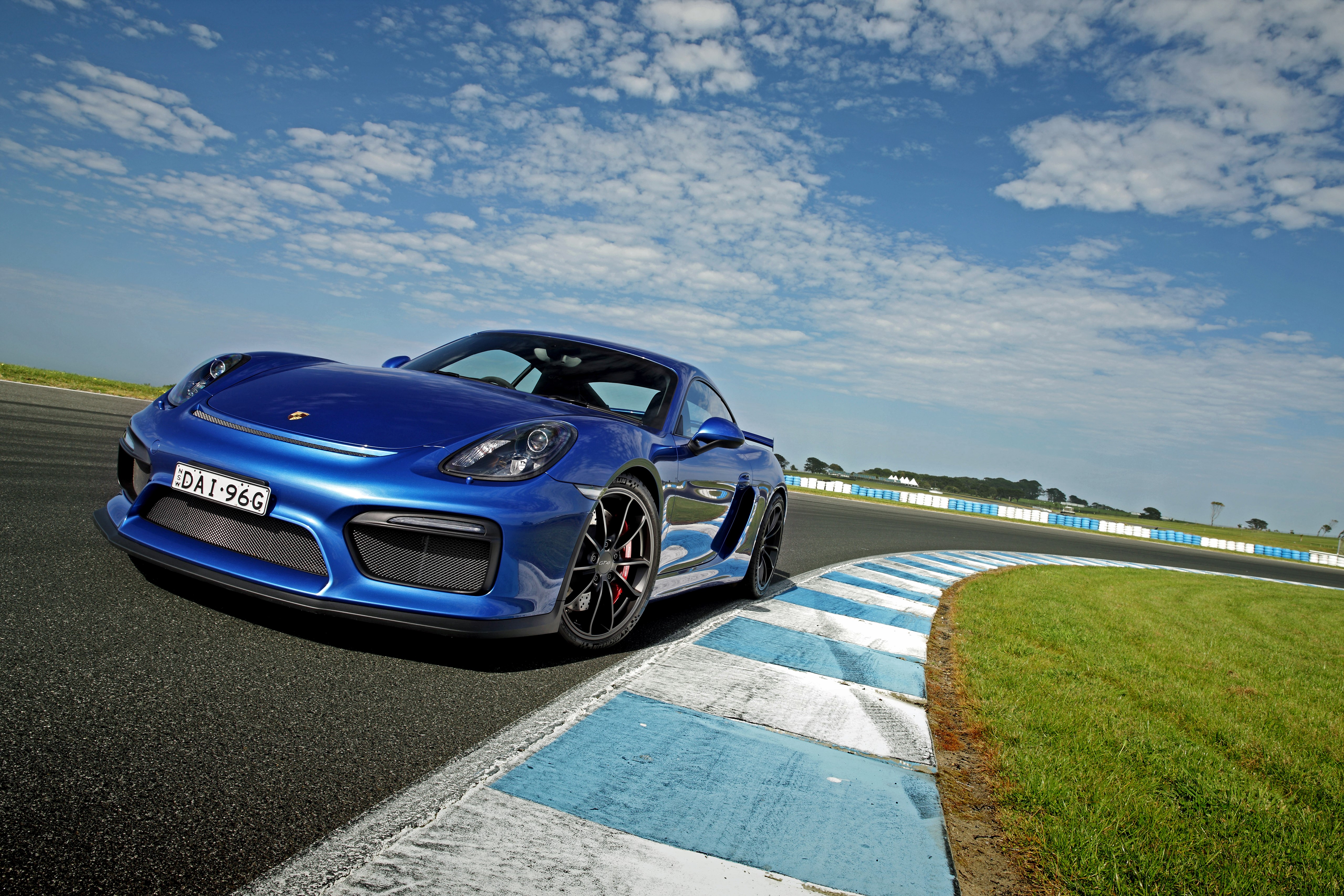 Blue Porsche Cayman GT4 on a Racetrack HD Wallpaper