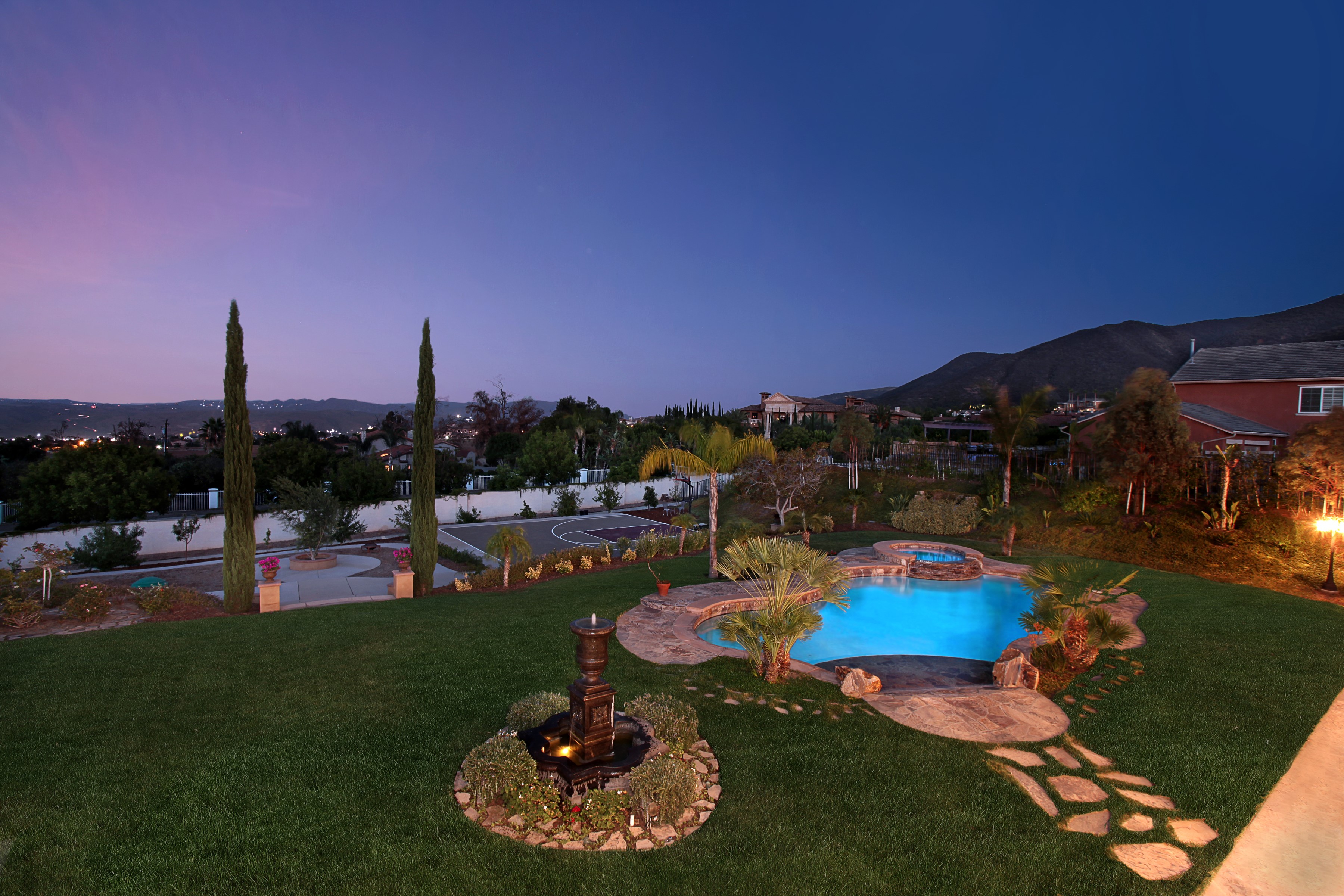 Backyard with pool and fountain at dusk HD Wallpaper