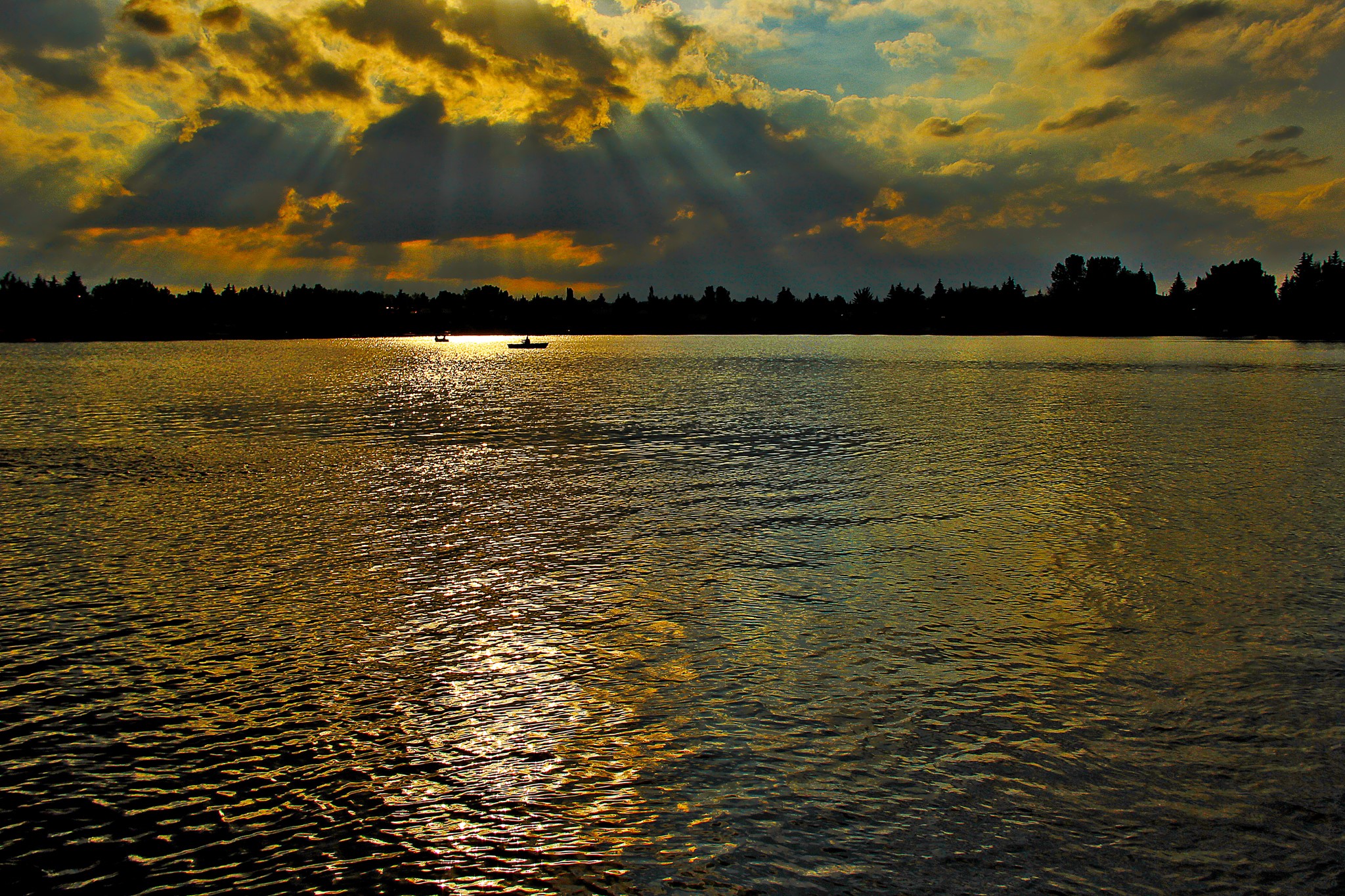 Sunset over a river with boats and silhouetted trees HD Wallpaper