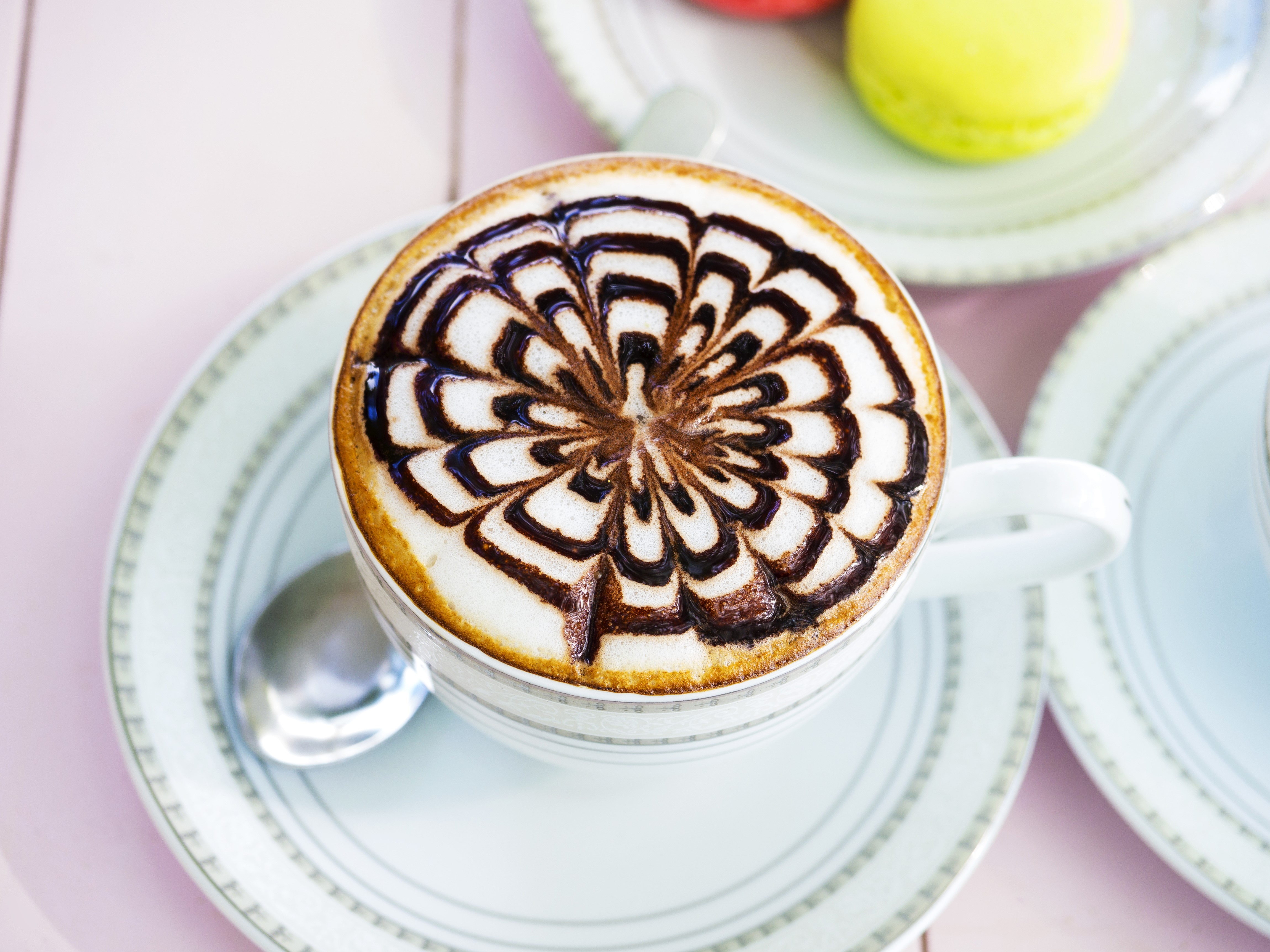Coffee with chocolate art on a saucer HD Wallpaper