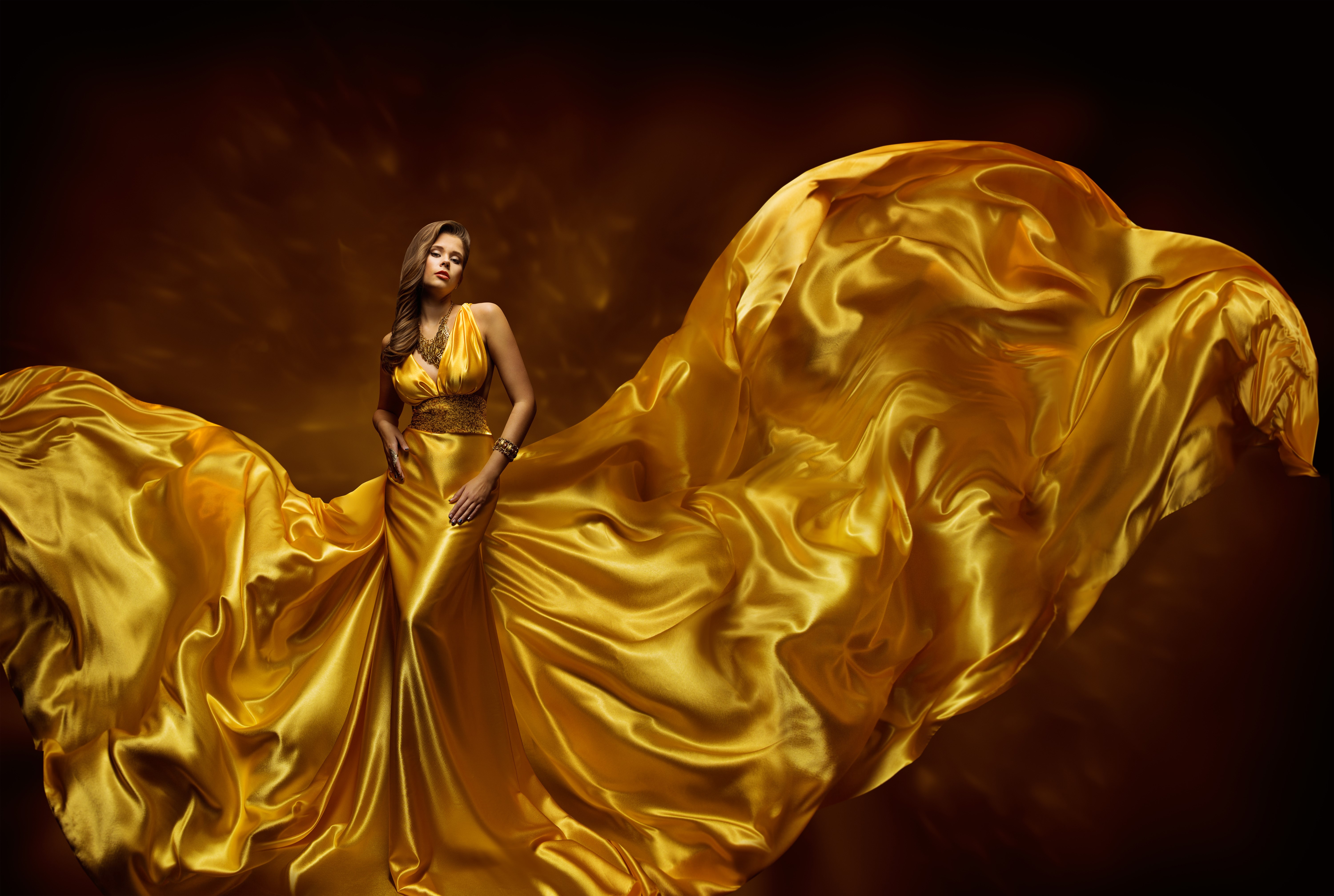 Woman in a flowing gold dress HD Wallpaper