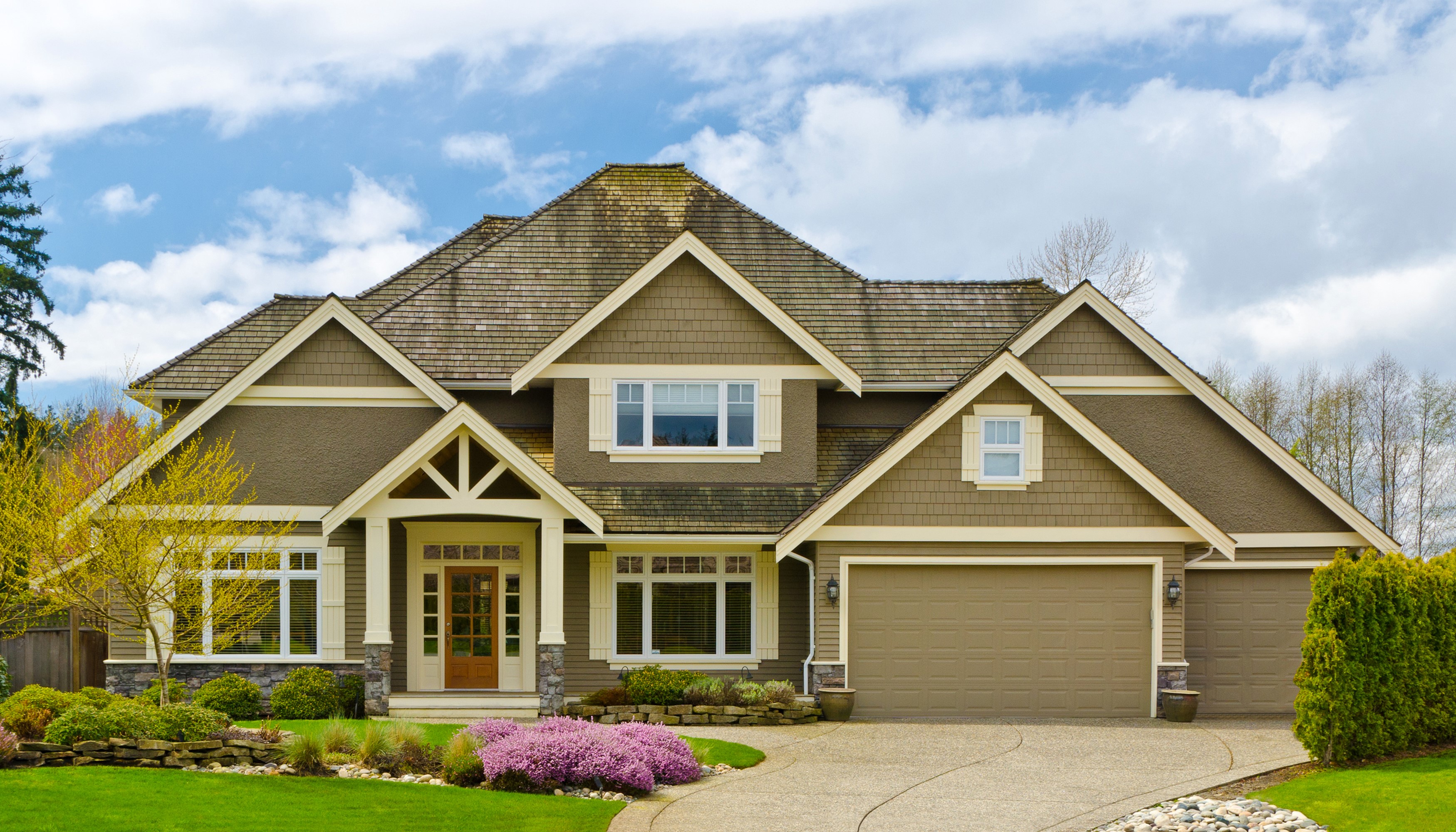 A large suburban house with a well-maintained lawn and garden. HD Wallpaper