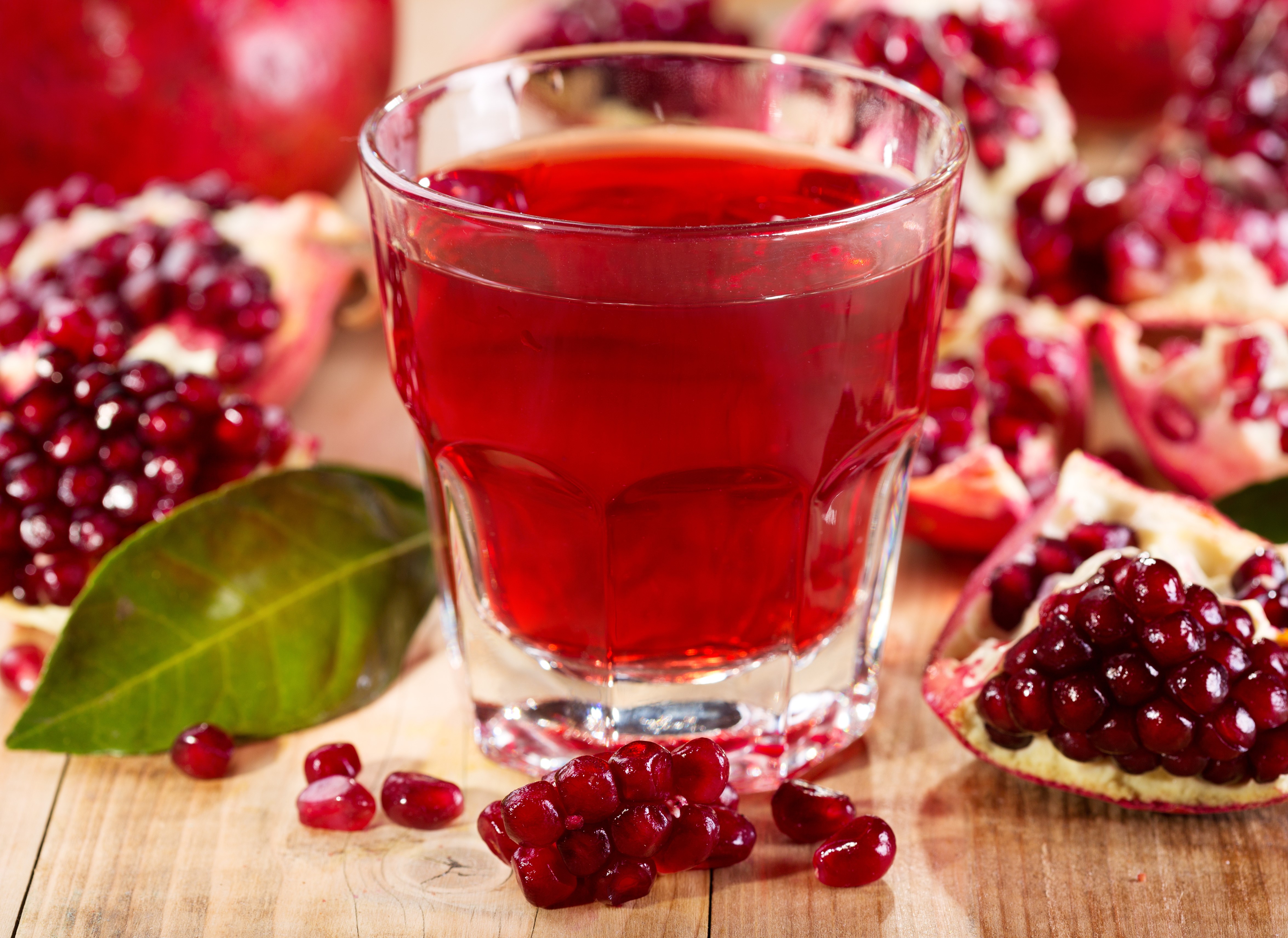 Pomegranate juice in a highball glass with pomegranates HD Wallpaper