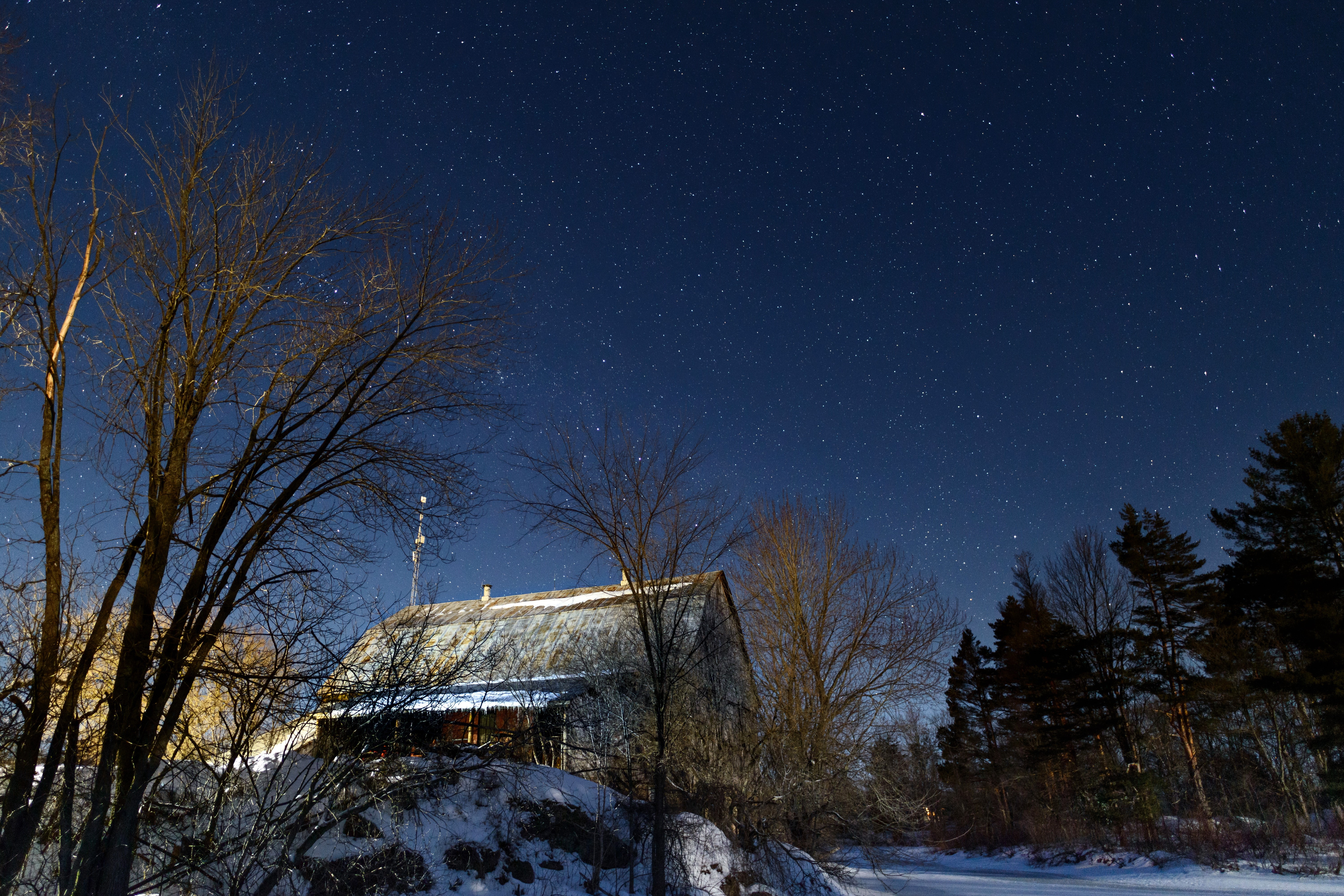 Winter night sky over a snowy house and trees HD Wallpaper