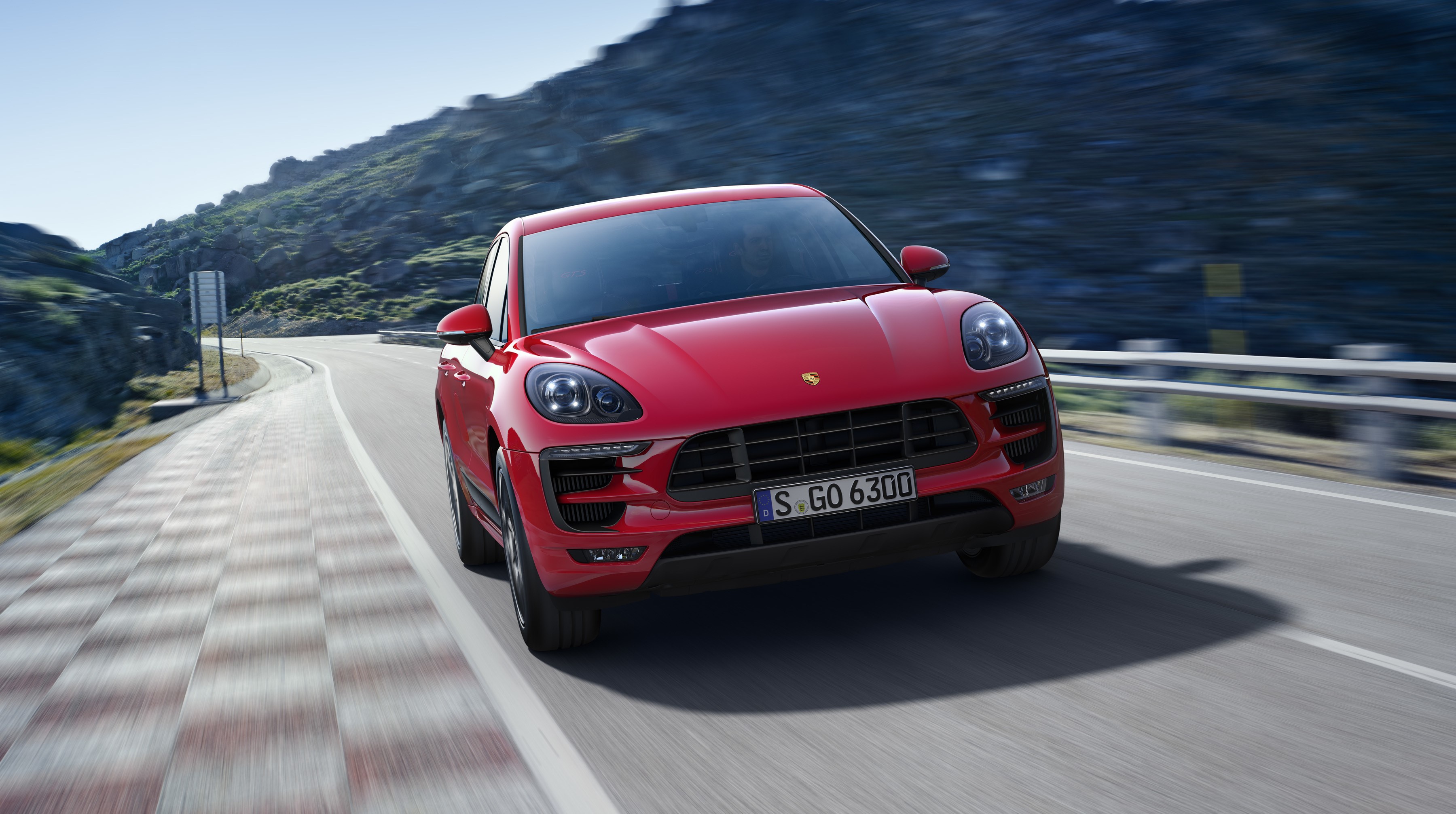Red Porsche Macan GTS driving on a mountain road HD Wallpaper