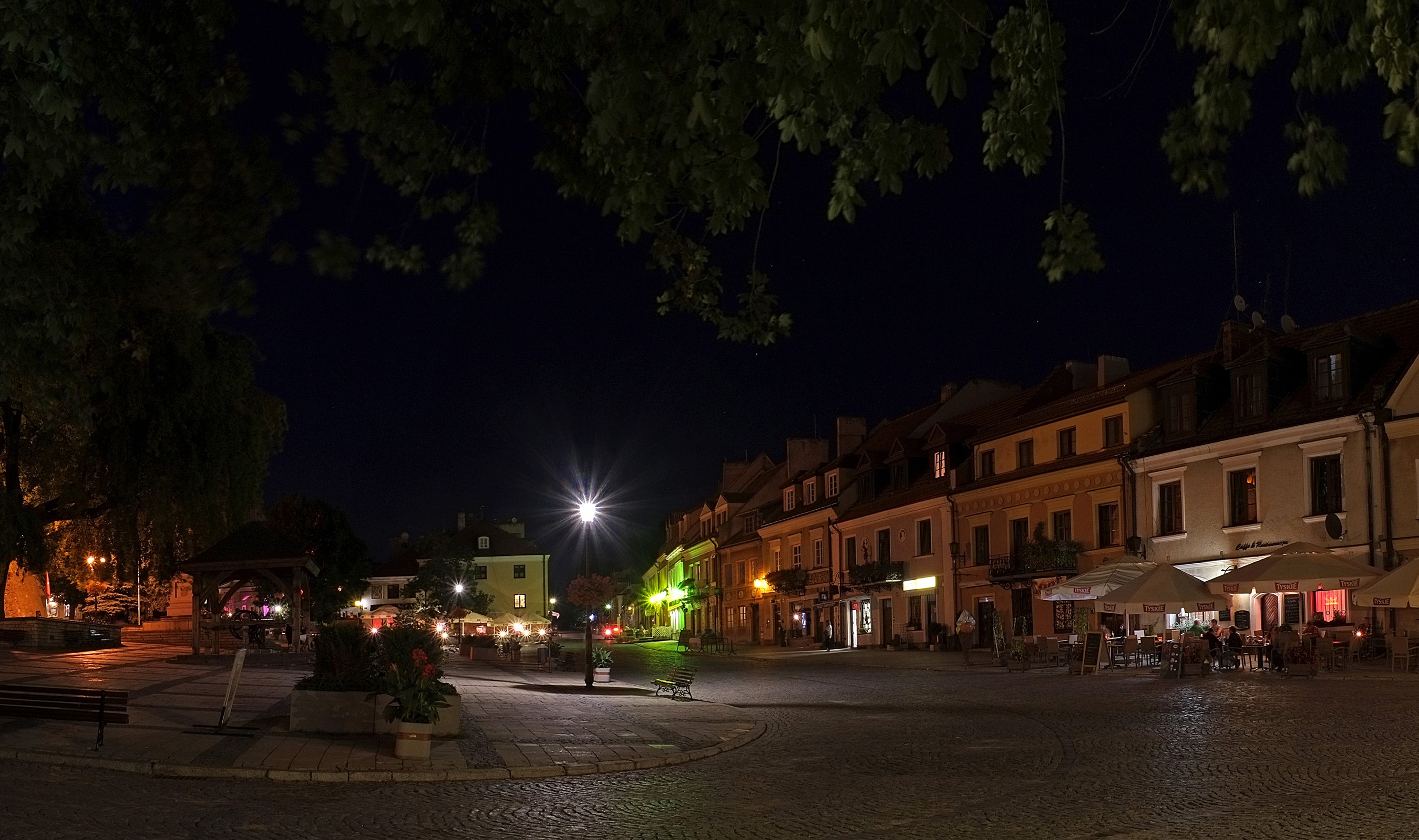 Night view of Sandomierz town square with buildings and street lights HD Wallpaper