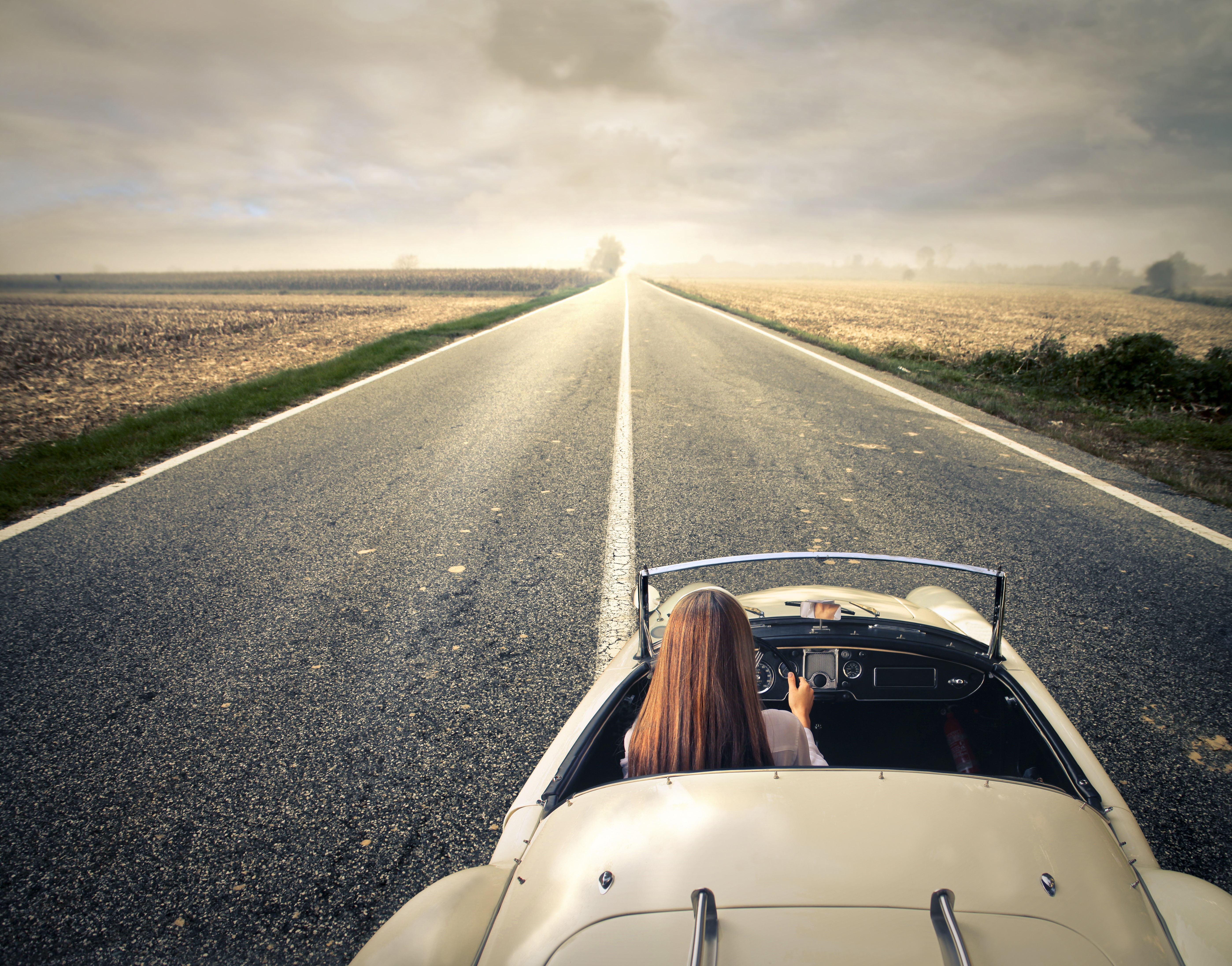 Woman driving a convertible on a road HD Wallpaper
