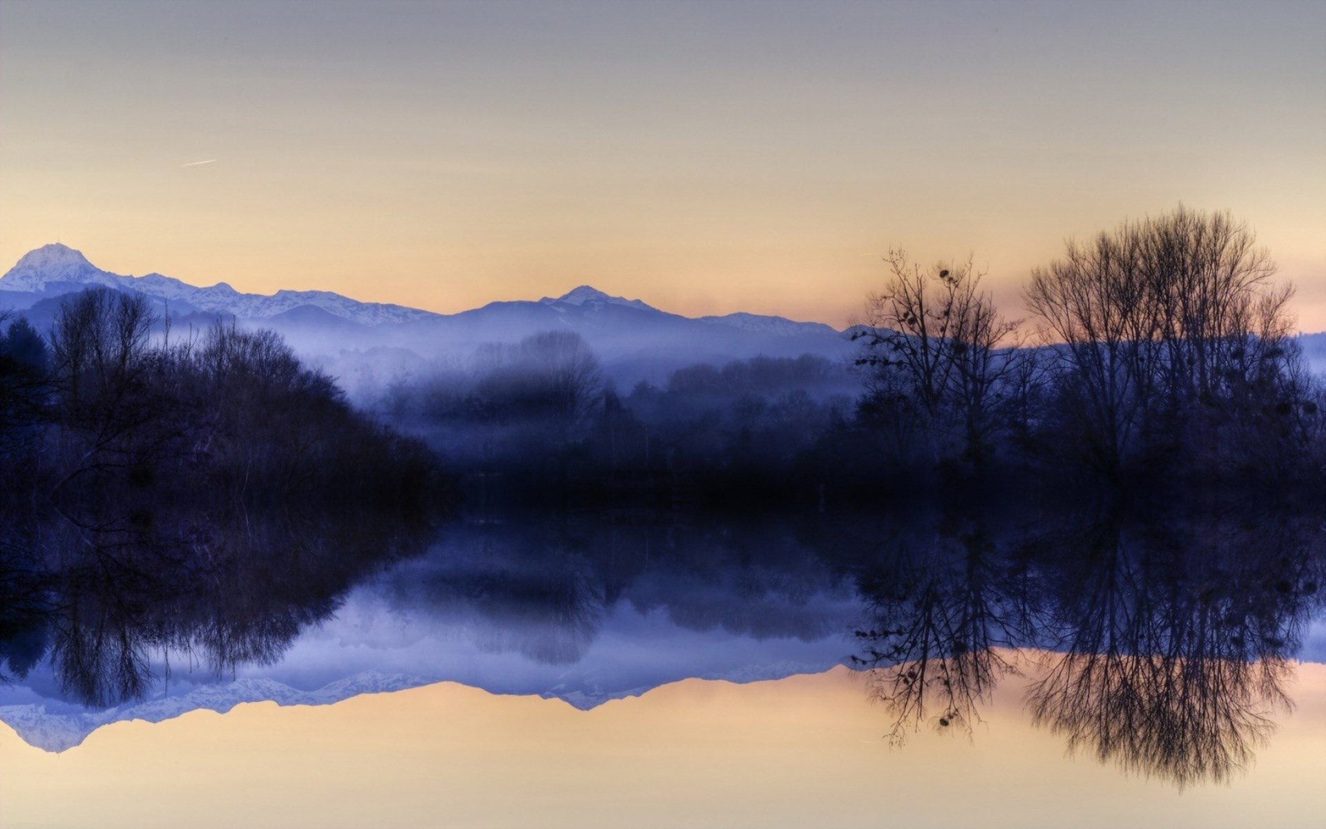 Reflection of misty mountains and trees in water at sunset HD Wallpaper