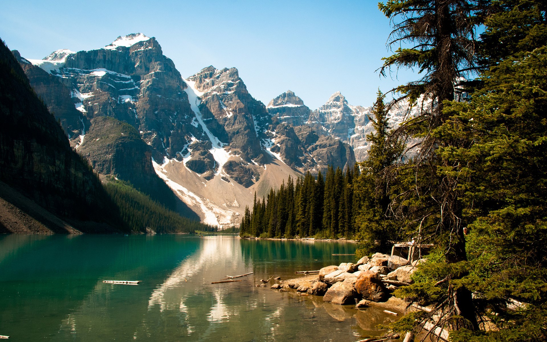 Turquoise lake with snow-capped mountains and pine trees HD Wallpaper