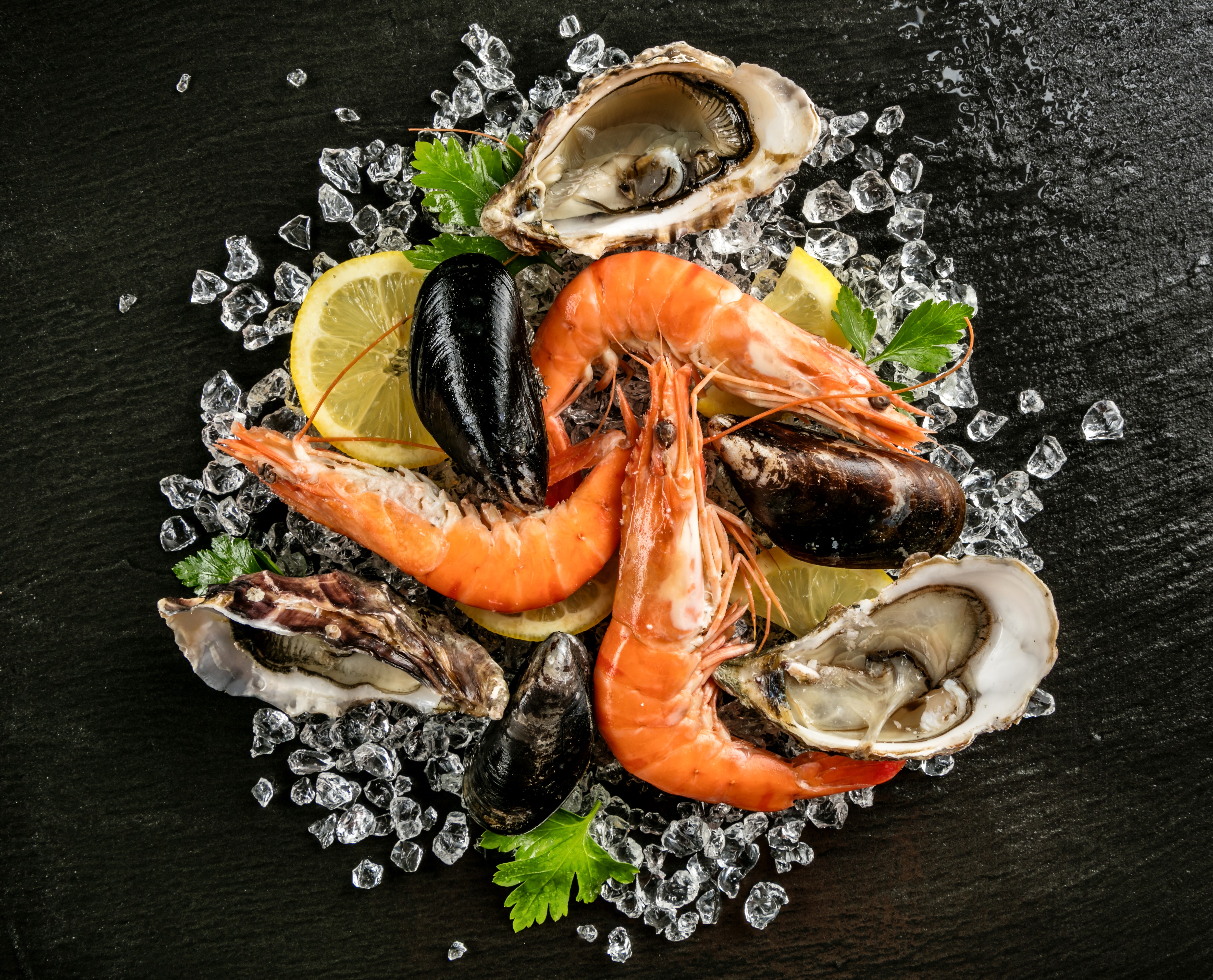 Seafood platter with shrimp, oysters, and mussels on ice HD Wallpaper