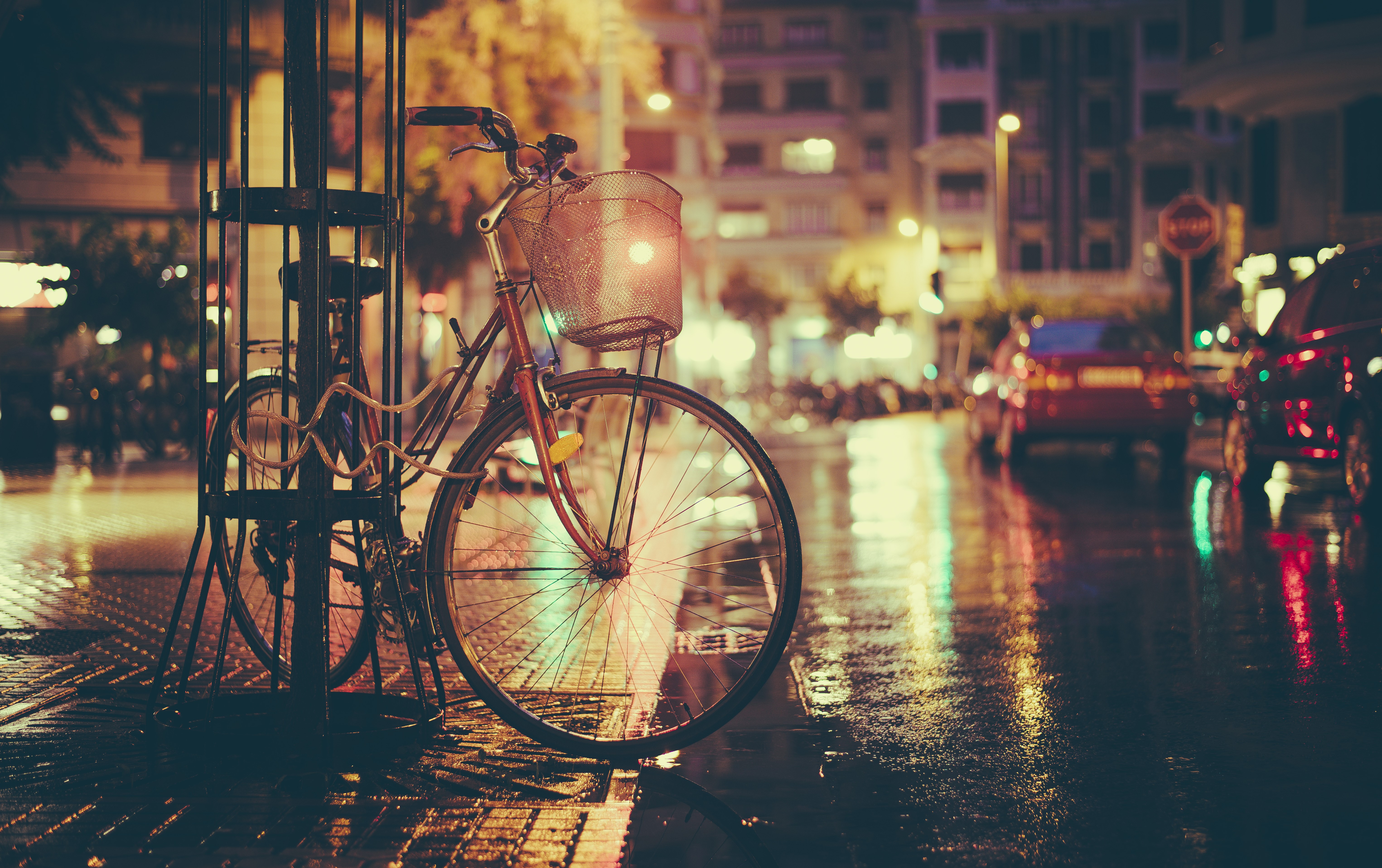 Bicycle parked on a wet city street at night HD Wallpaper