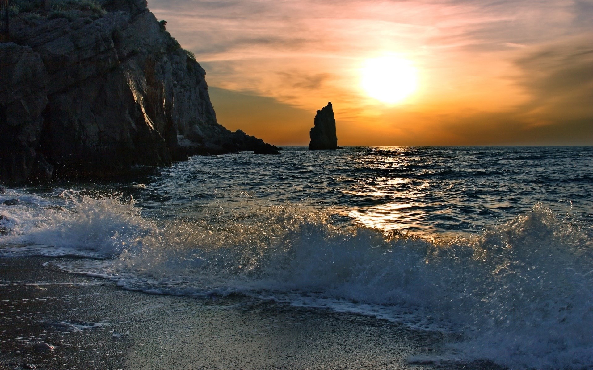 Sunset over the ocean with rocky cliffs and a sea stack HD Wallpaper