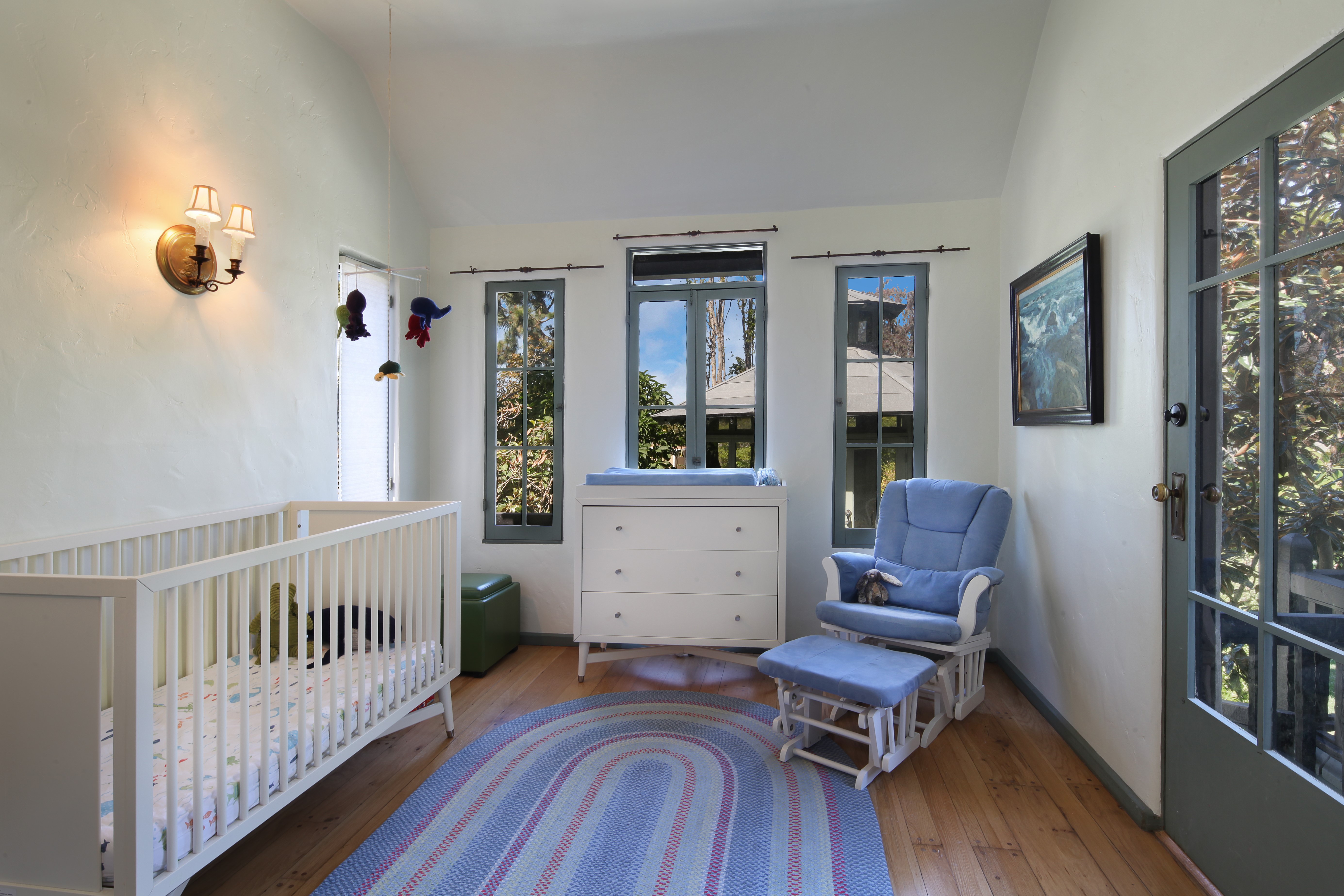 Nursery room with crib, changing table, and glider HD Wallpaper
