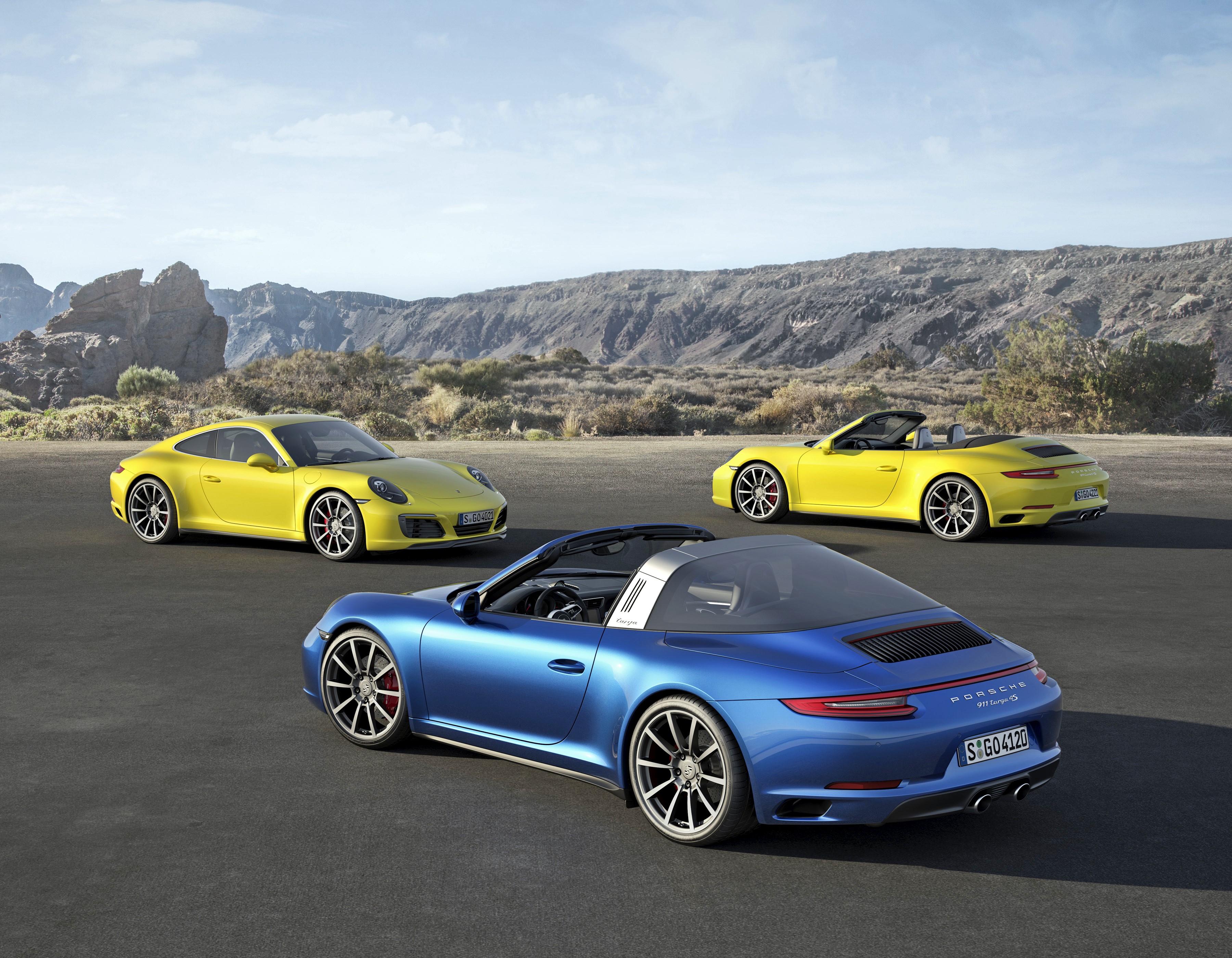Three Porsche 911 cars in a desert landscape HD Wallpaper