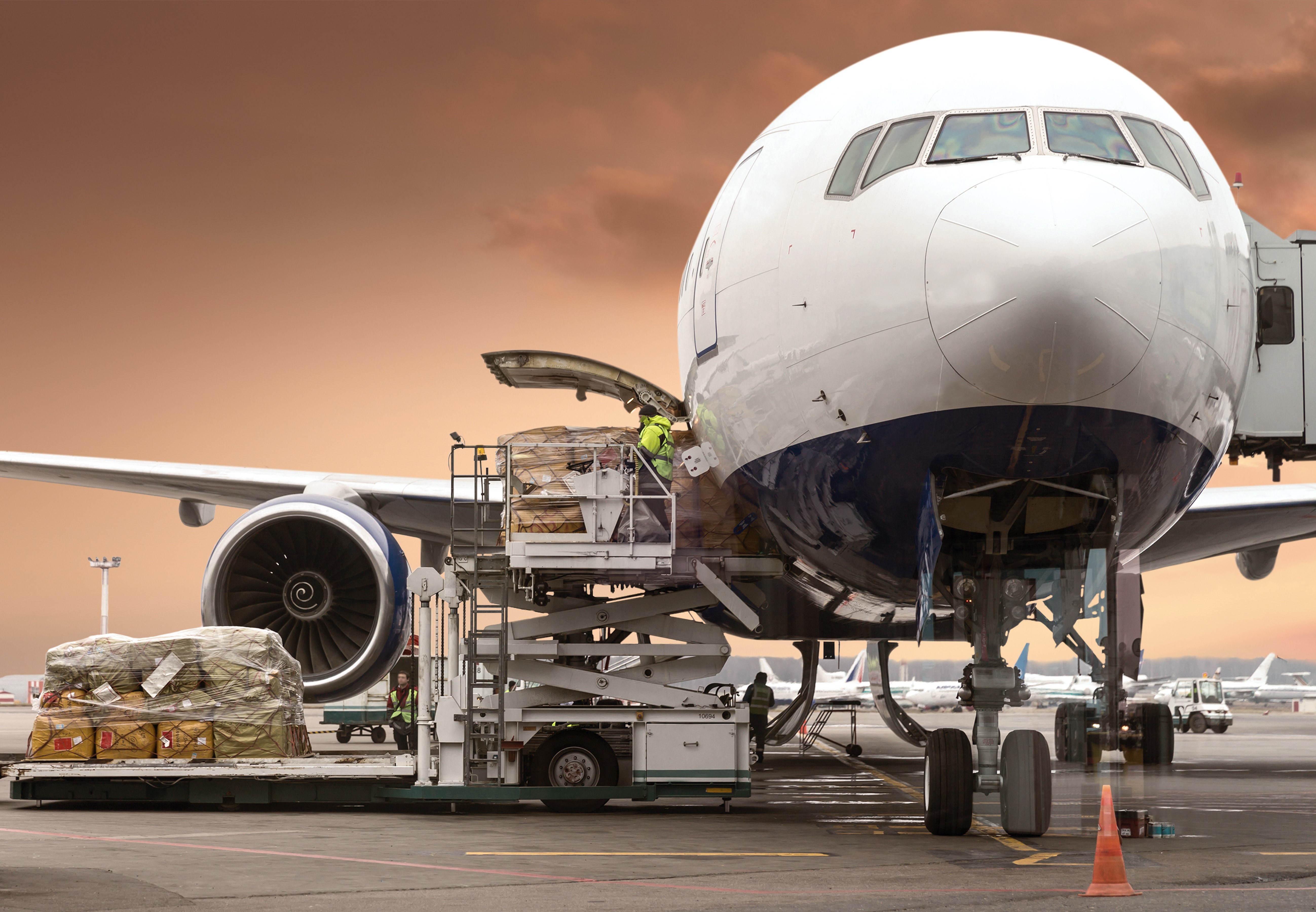 Cargo airplane being loaded at sunset HD Wallpaper