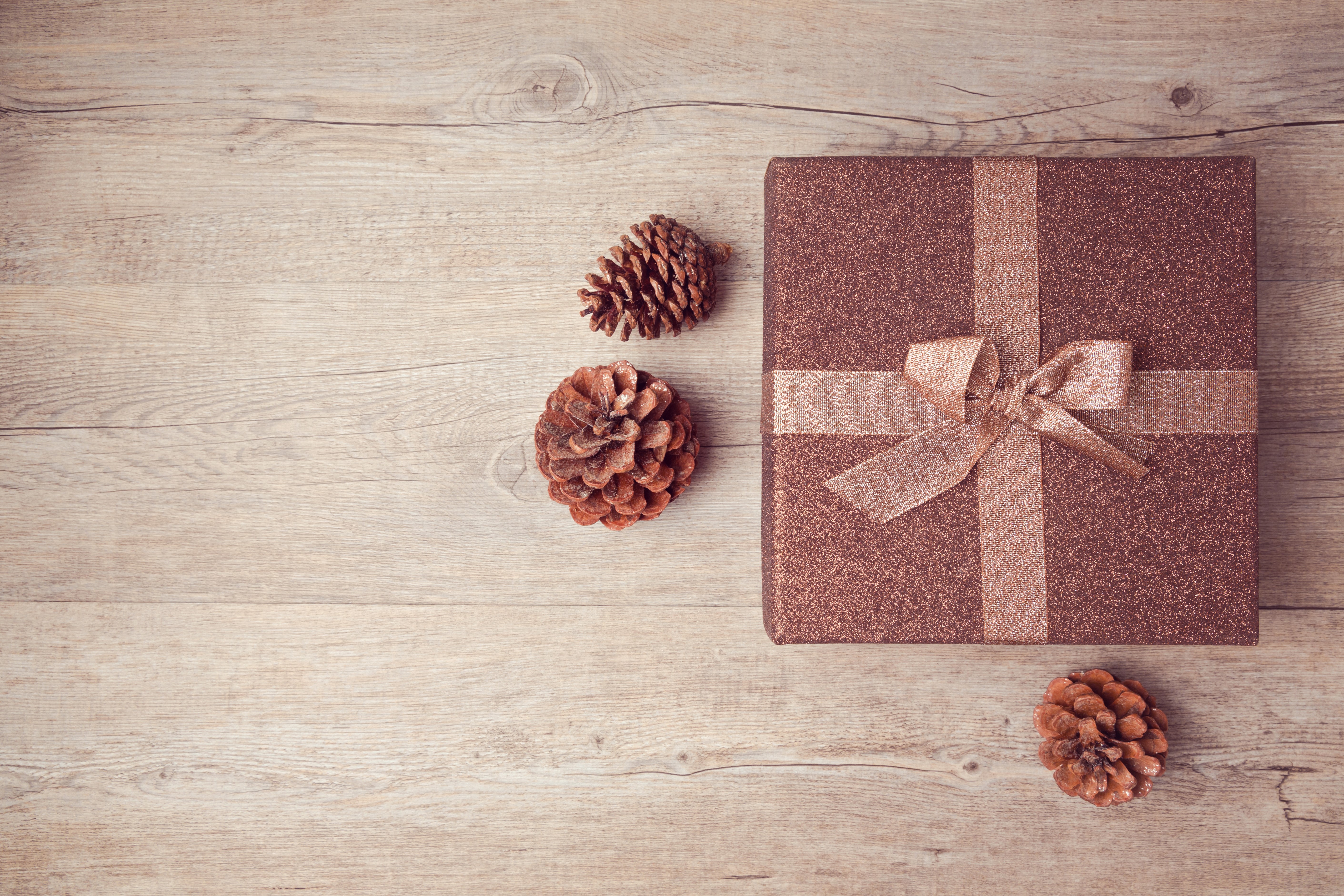 Gift box with pine cones on wooden background HD Wallpaper