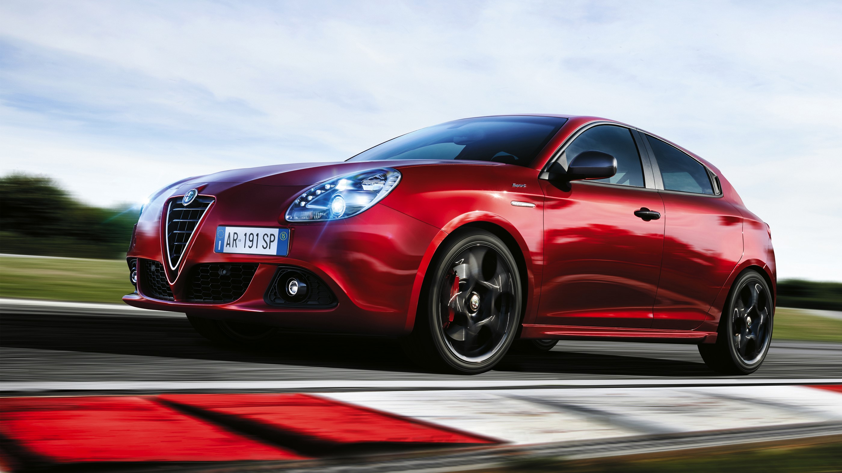 Red Alfa Romeo Giulietta on a Racetrack HD Wallpaper
