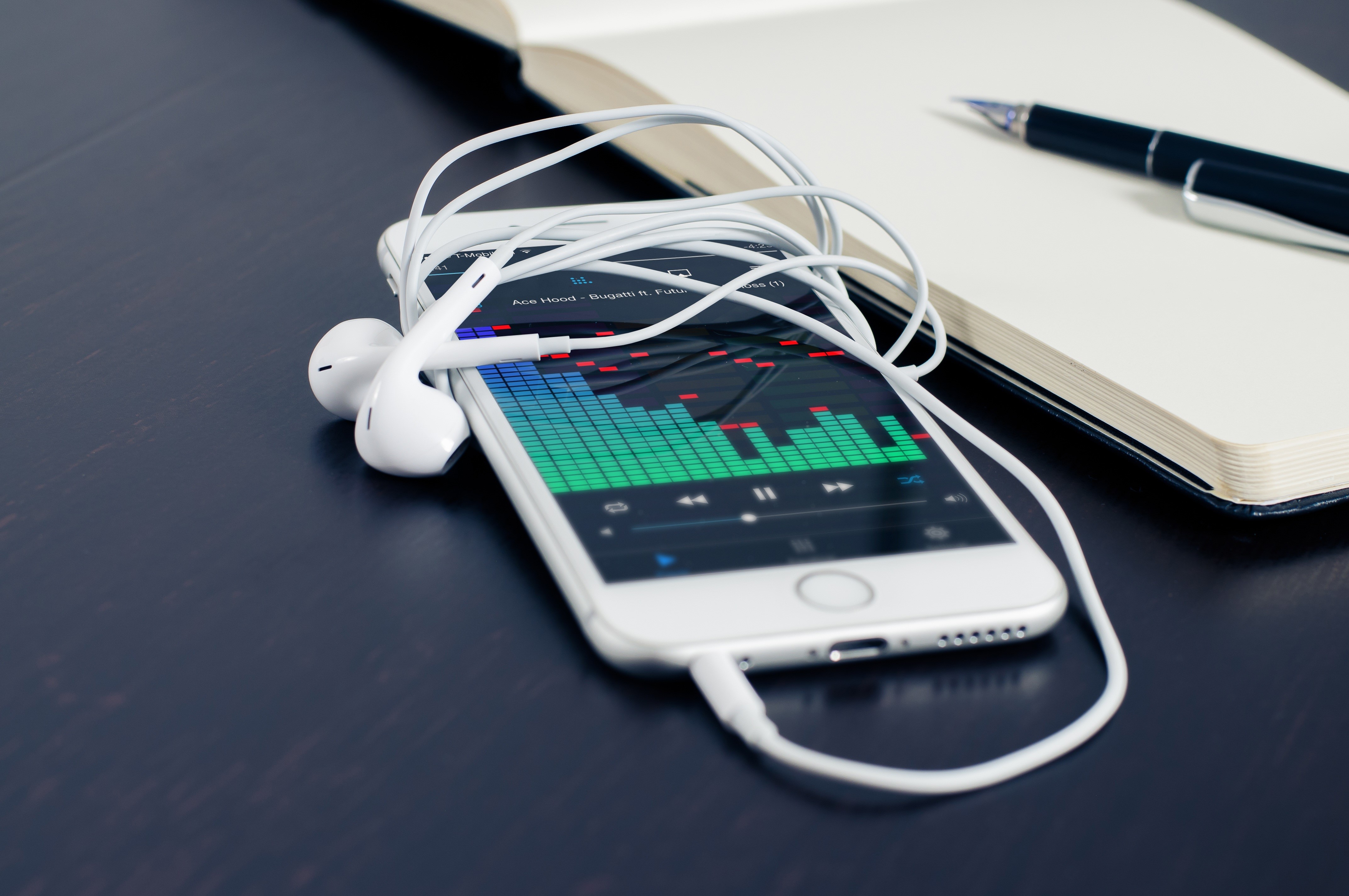 iPhone with headphones and notebook HD Wallpaper
