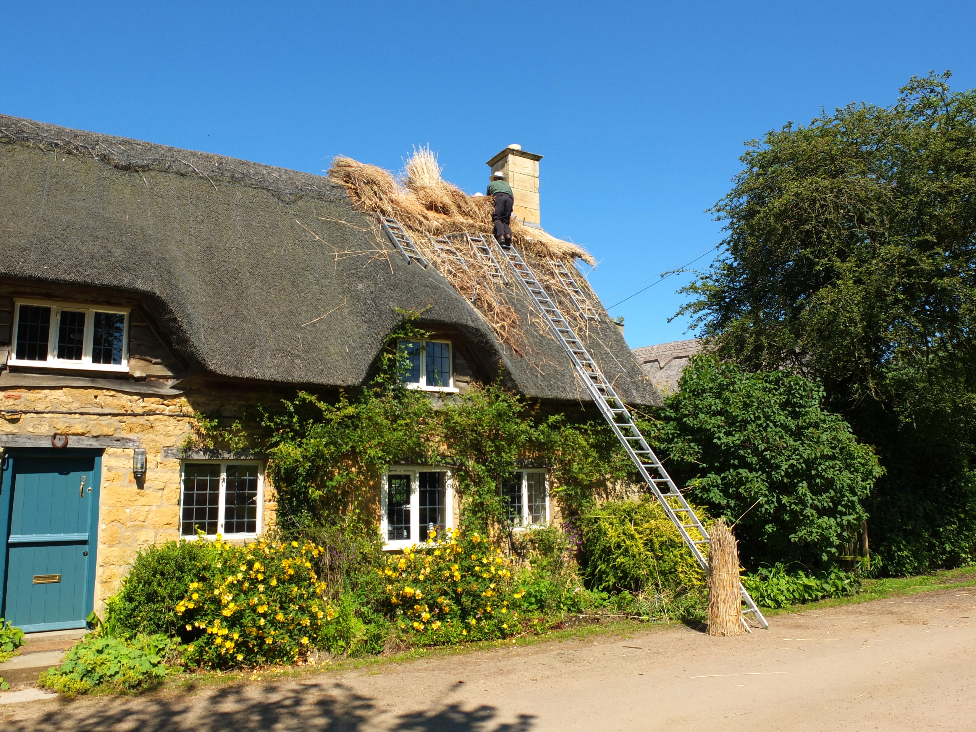 Thatched cottage roof repair in the Cotswolds, UK HD Wallpaper