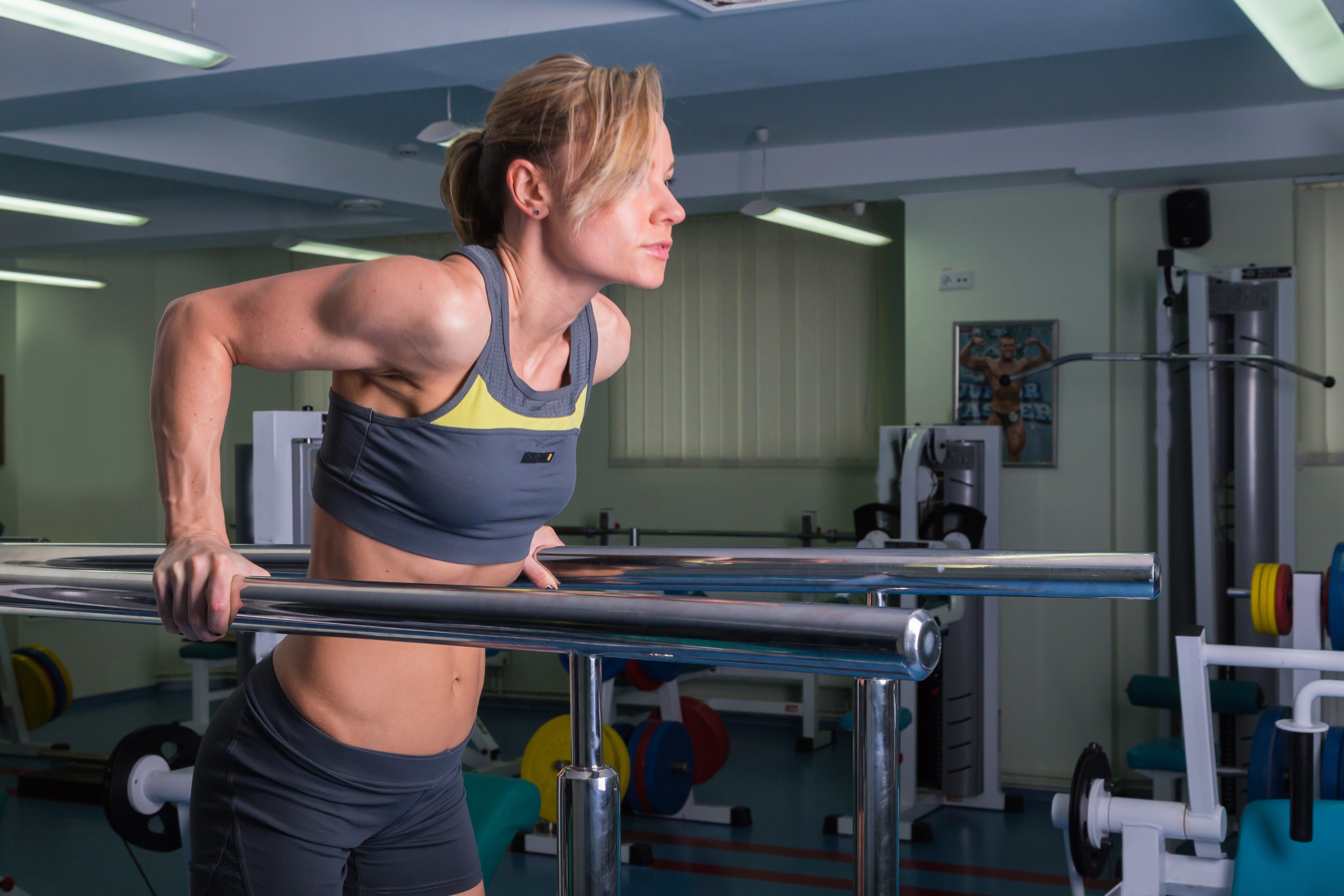 Woman doing dips in a gym HD Wallpaper