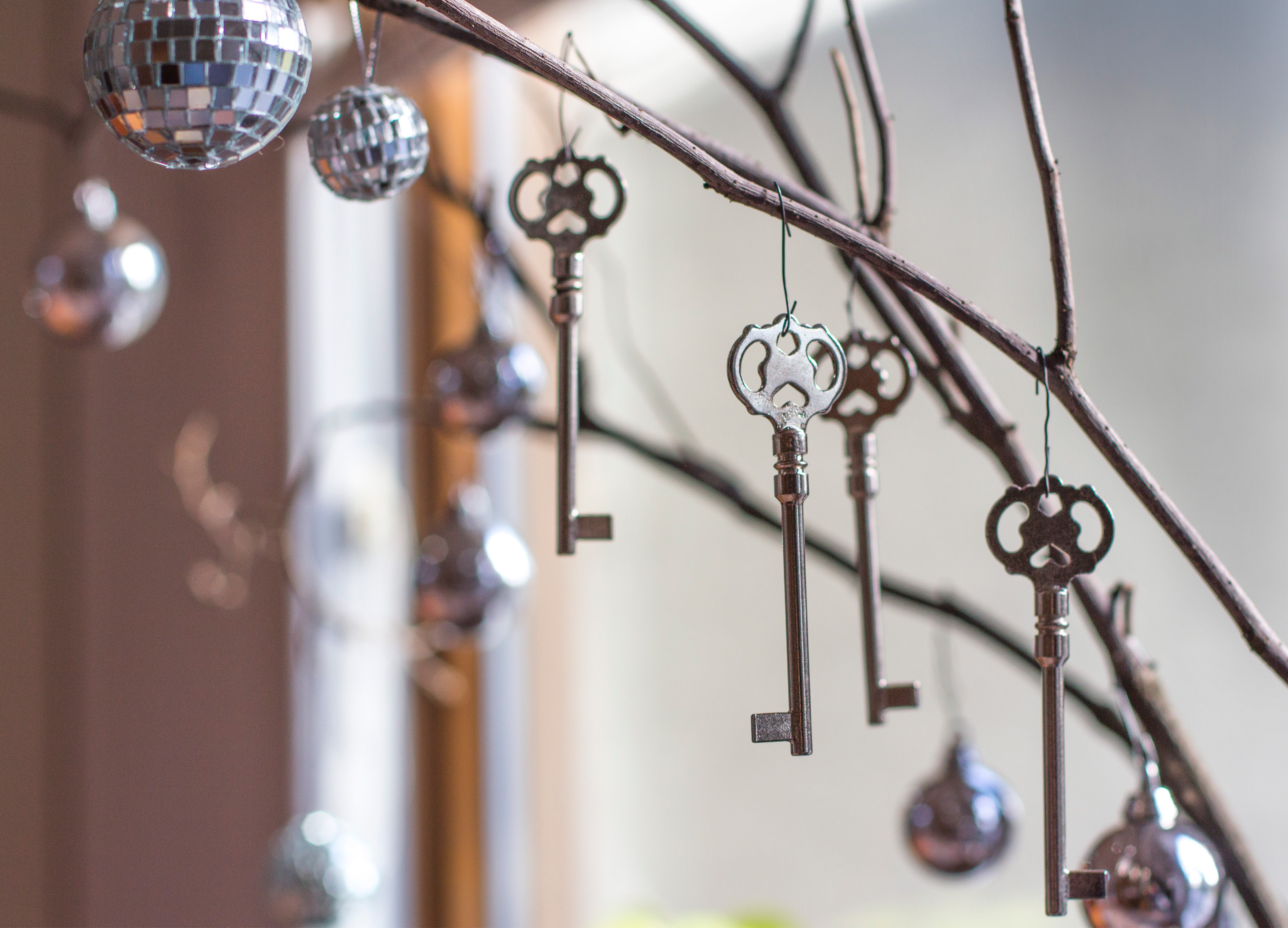 Keys and disco balls hanging from branches HD Wallpaper