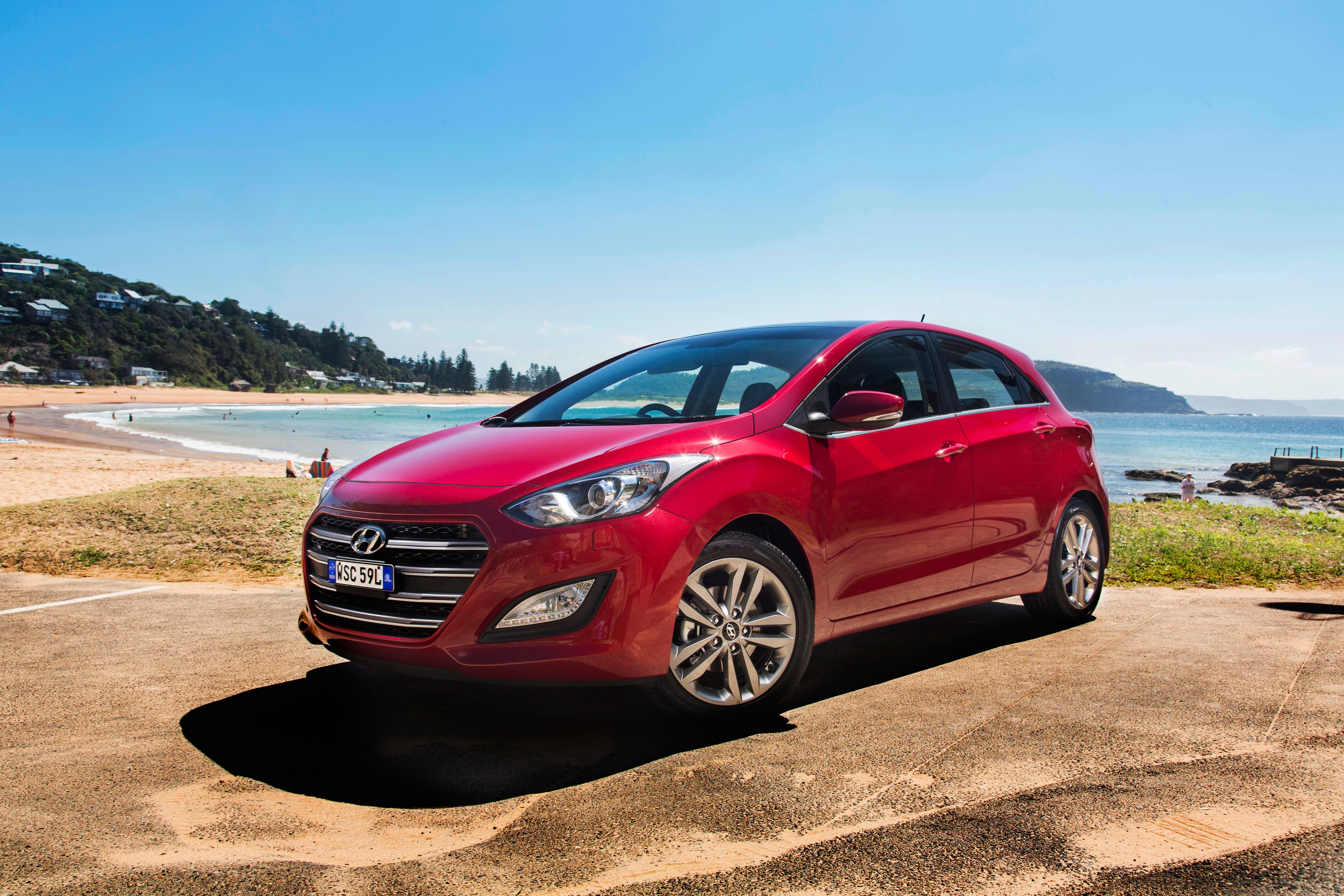 Red Hyundai i30 Hatchback on Beach Road HD Wallpaper
