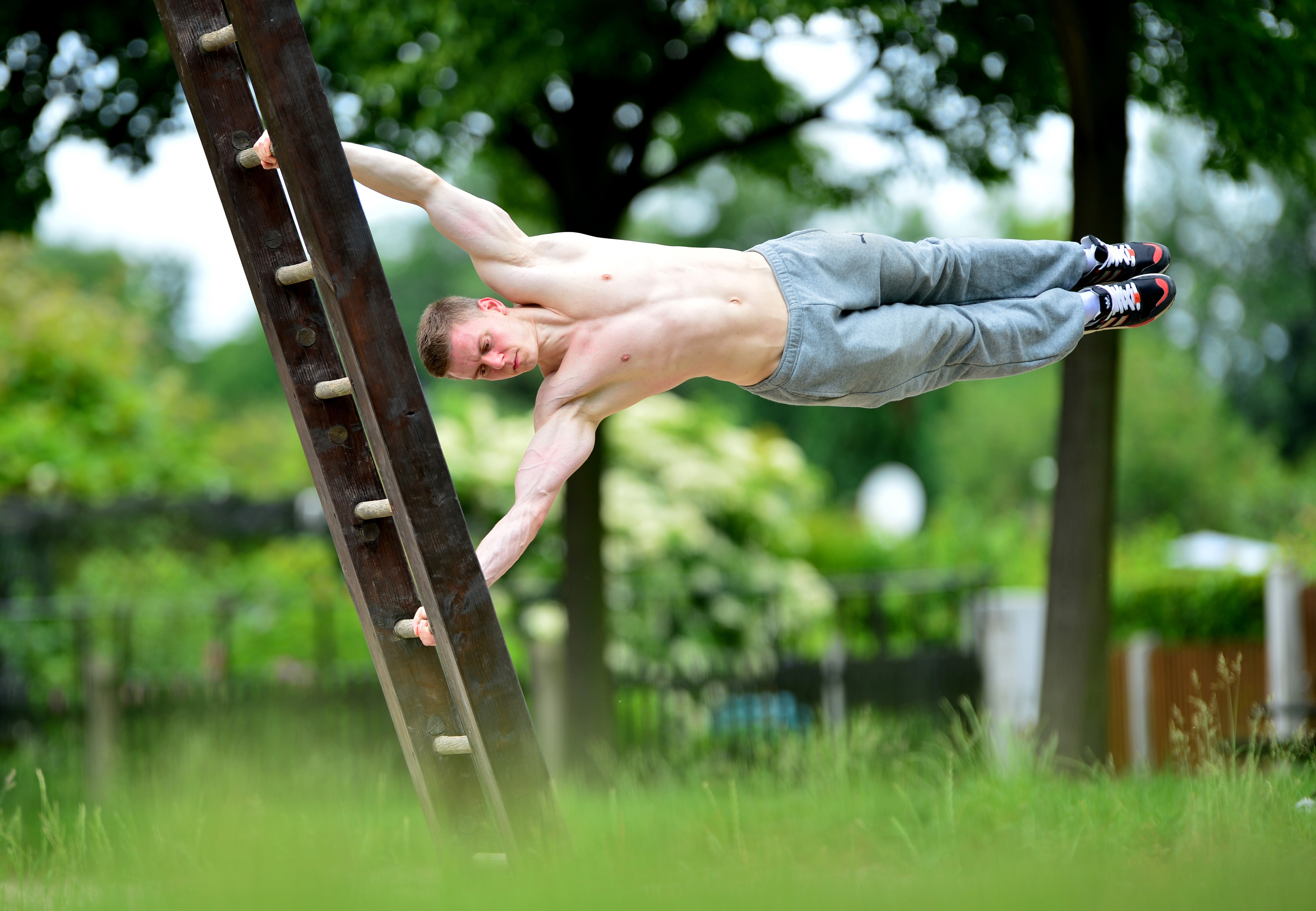 Man performing a human flag on a ladder HD Wallpaper