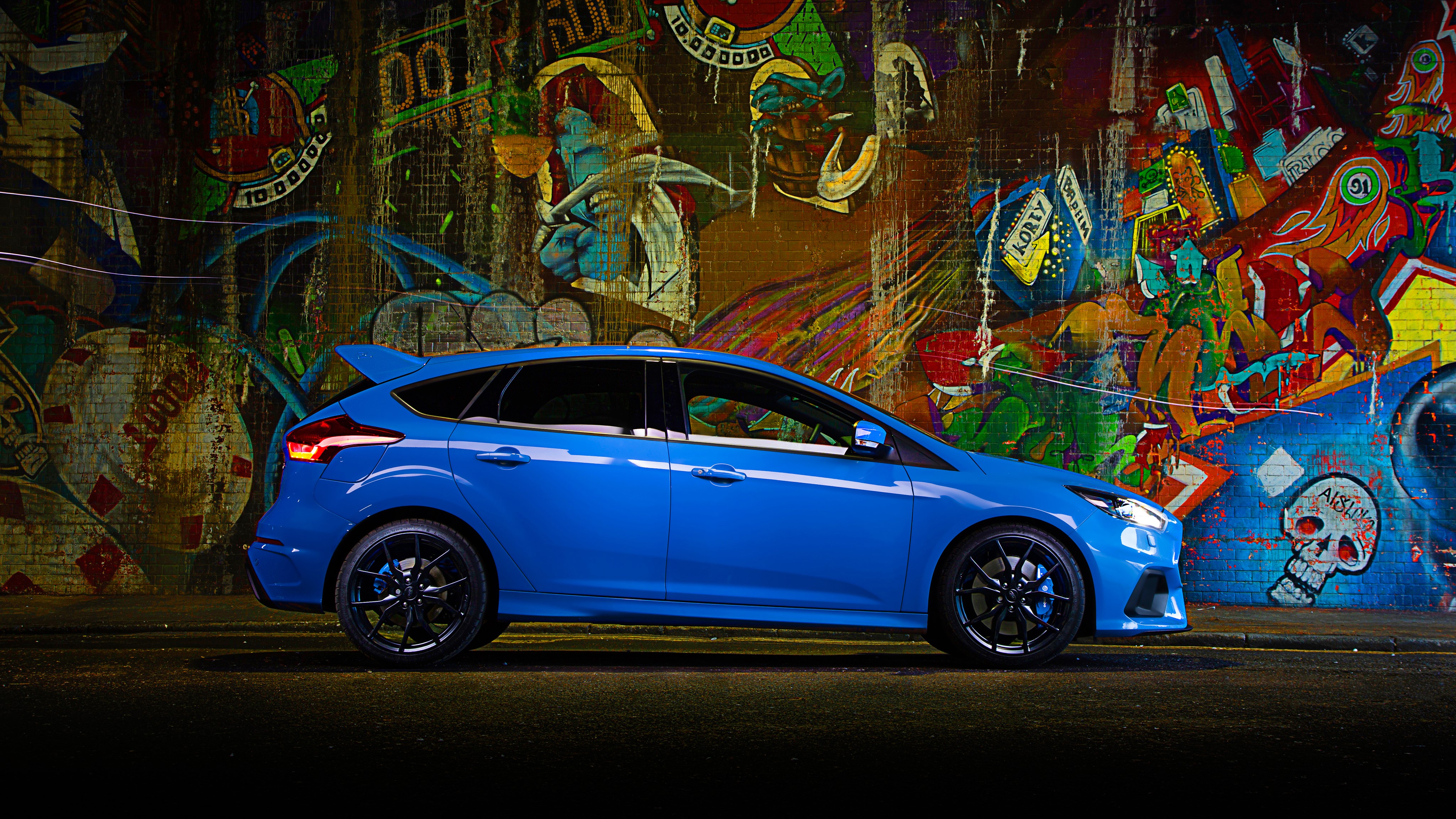 Blue 2016 Ford Focus RS parked against graffiti wall HD Wallpaper
