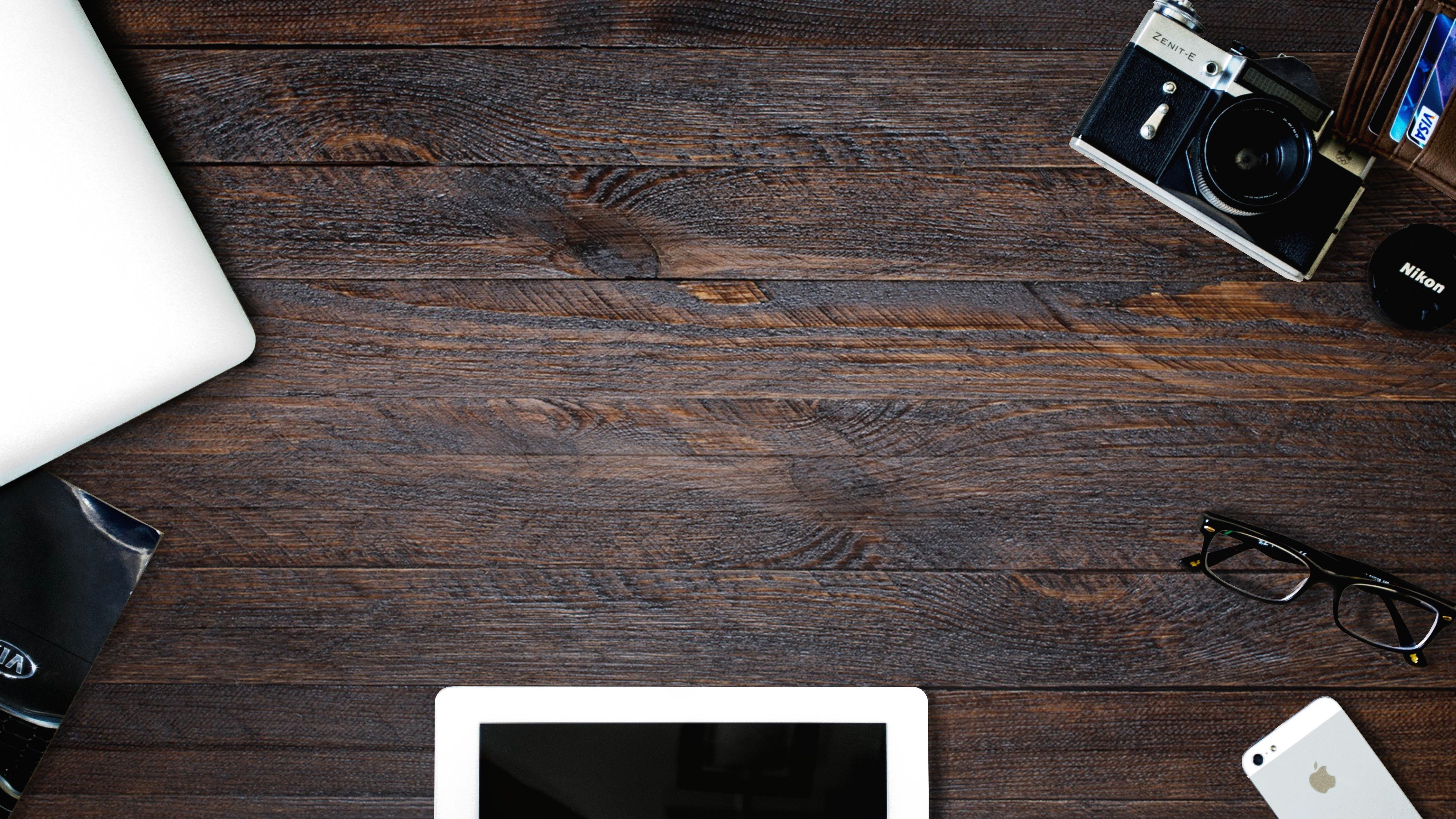 Desk with laptop, camera, wallet, glasses, and phone HD Wallpaper