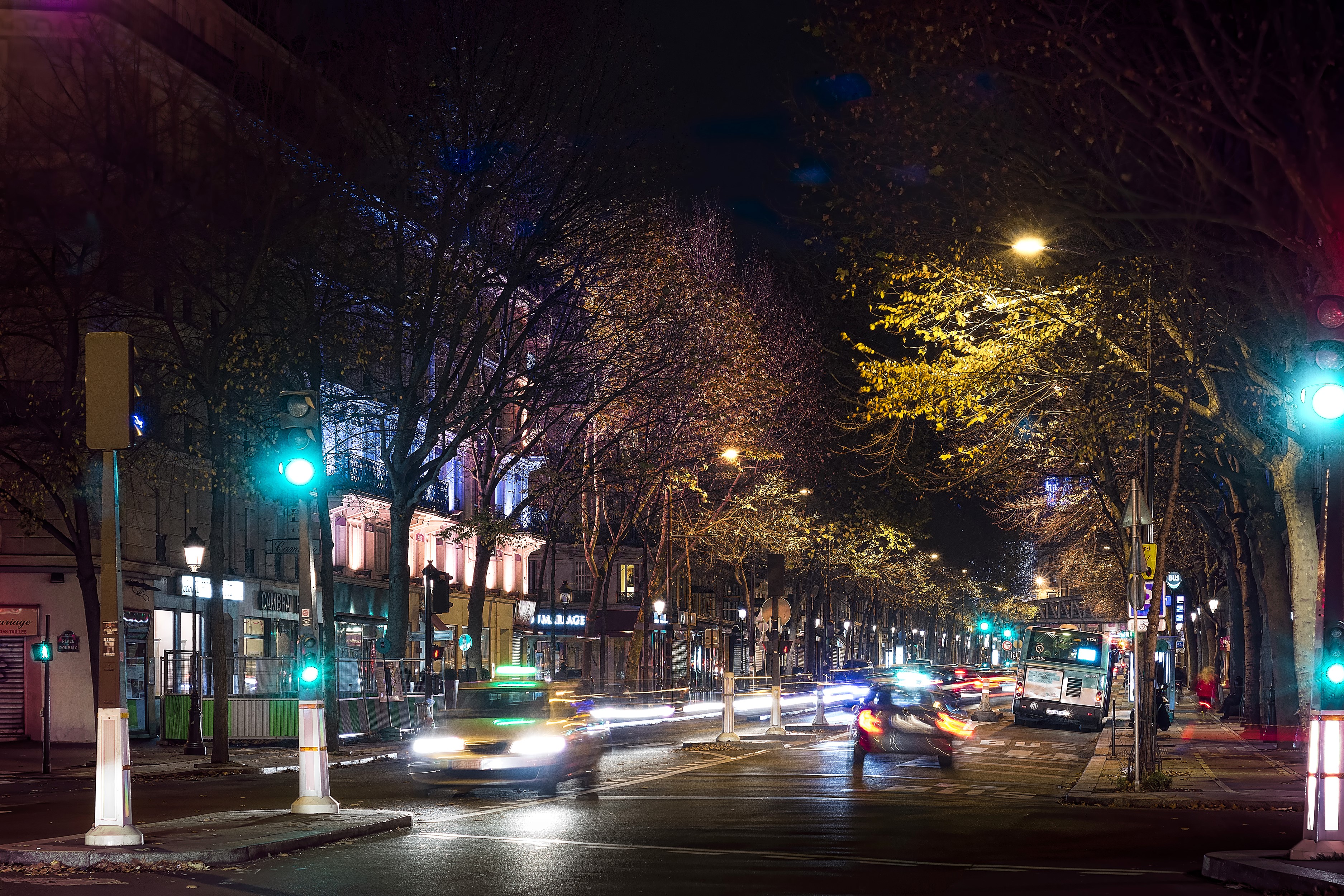 Paris street at night with traffic and trees HD Wallpaper