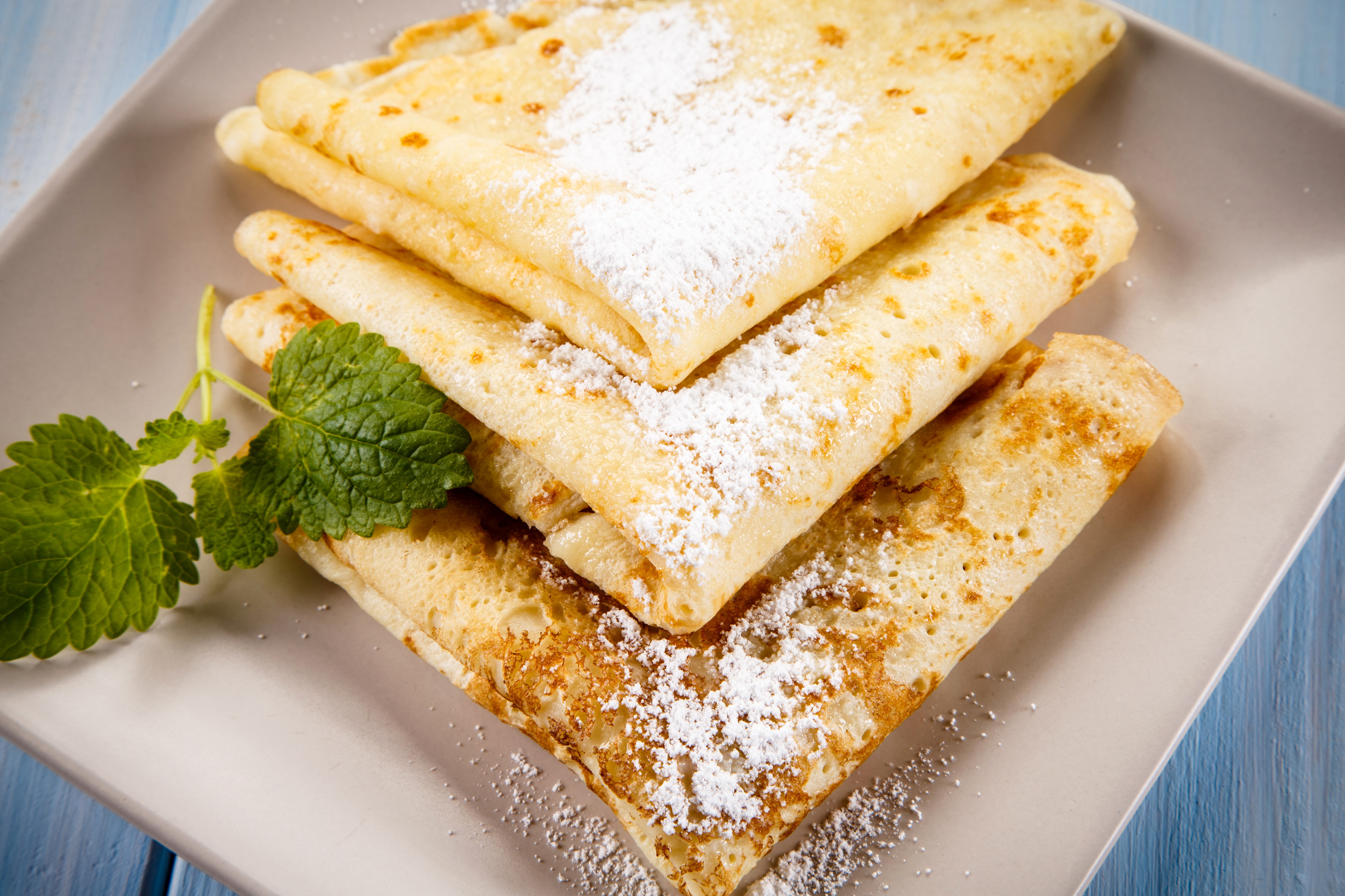 Stack of pancakes with powdered sugar and mint HD Wallpaper