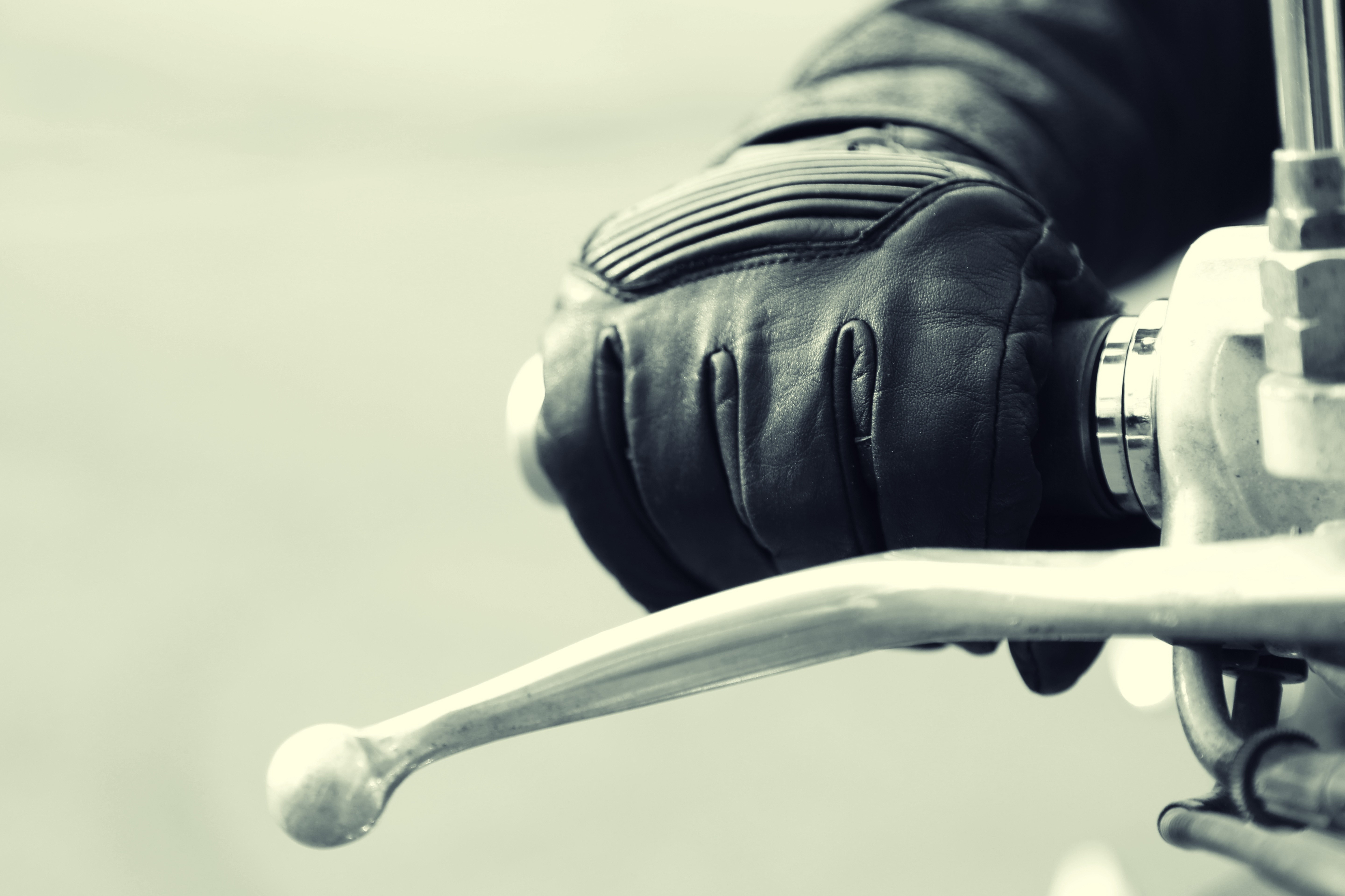 Motorcycle rider's gloved hand on handlebar HD Wallpaper