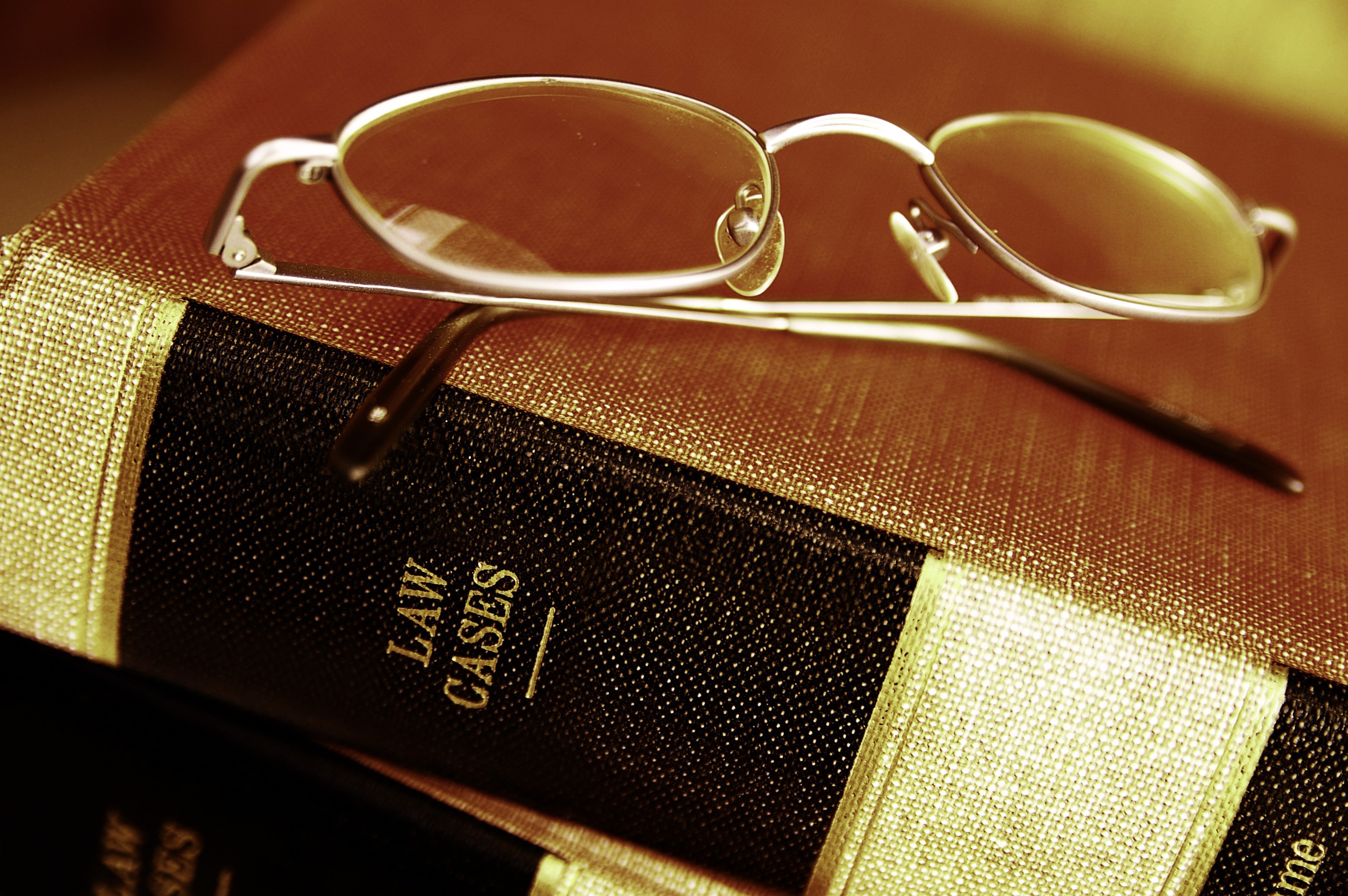 Glasses resting on law books HD Wallpaper