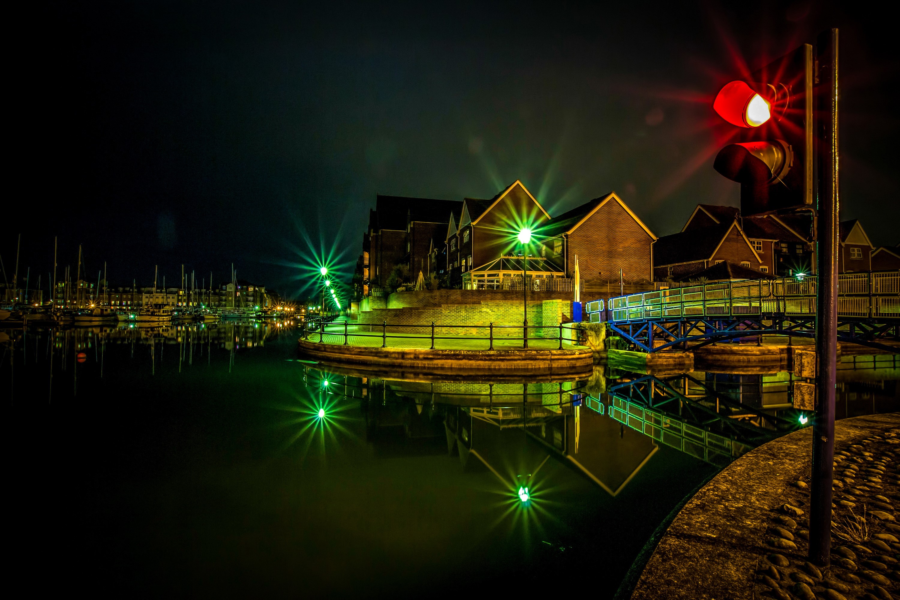 Night scene of a marina with houses and a traffic light HD Wallpaper