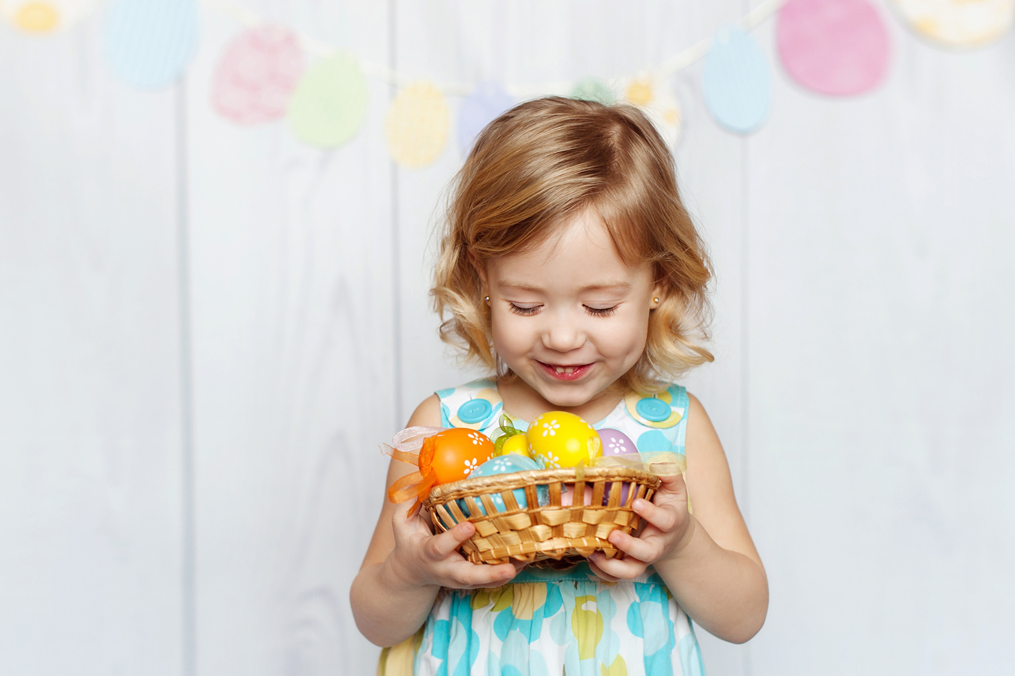 Little girl holding Easter eggs in a basket HD Wallpaper