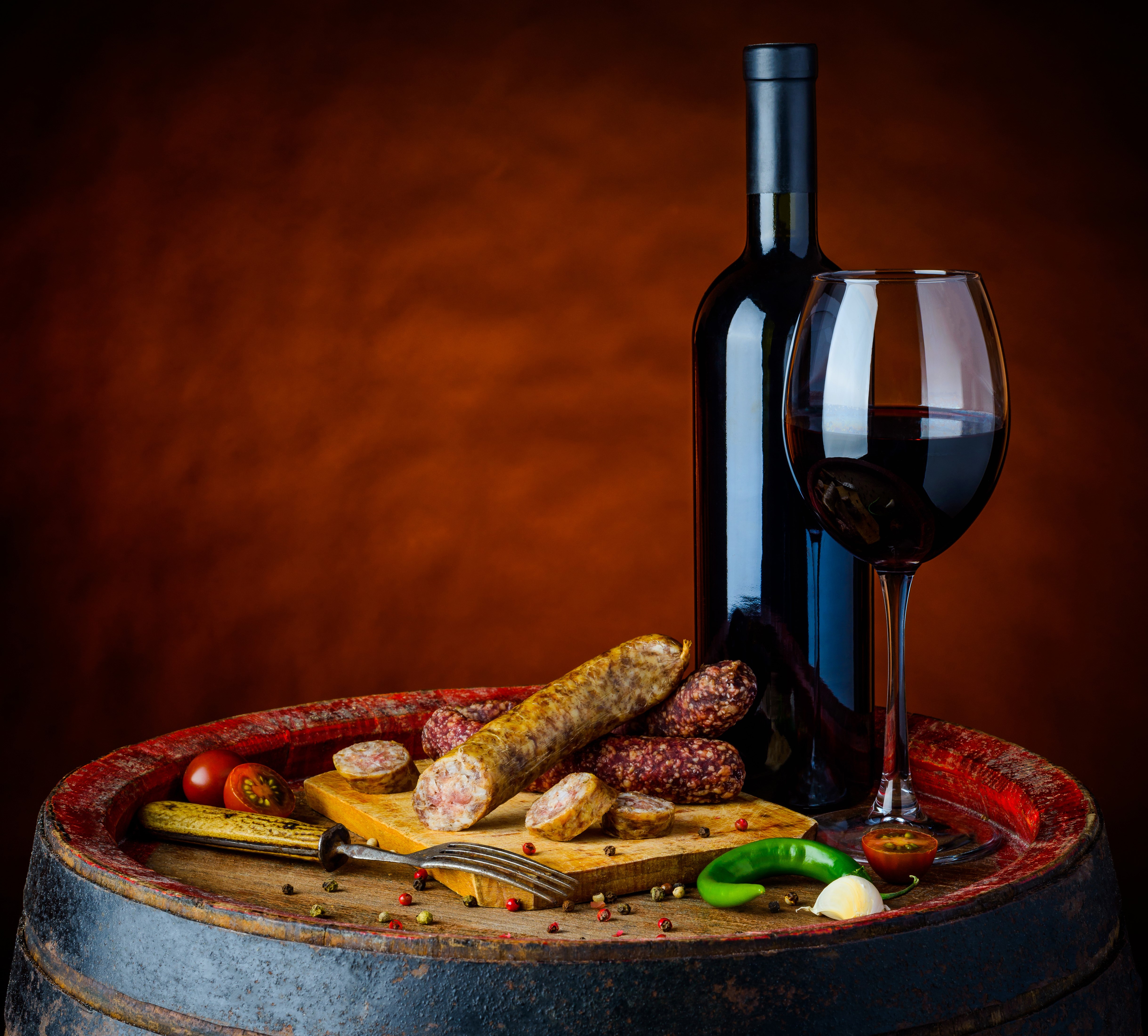 Wine bottle and glass with sausages on a barrel HD Wallpaper
