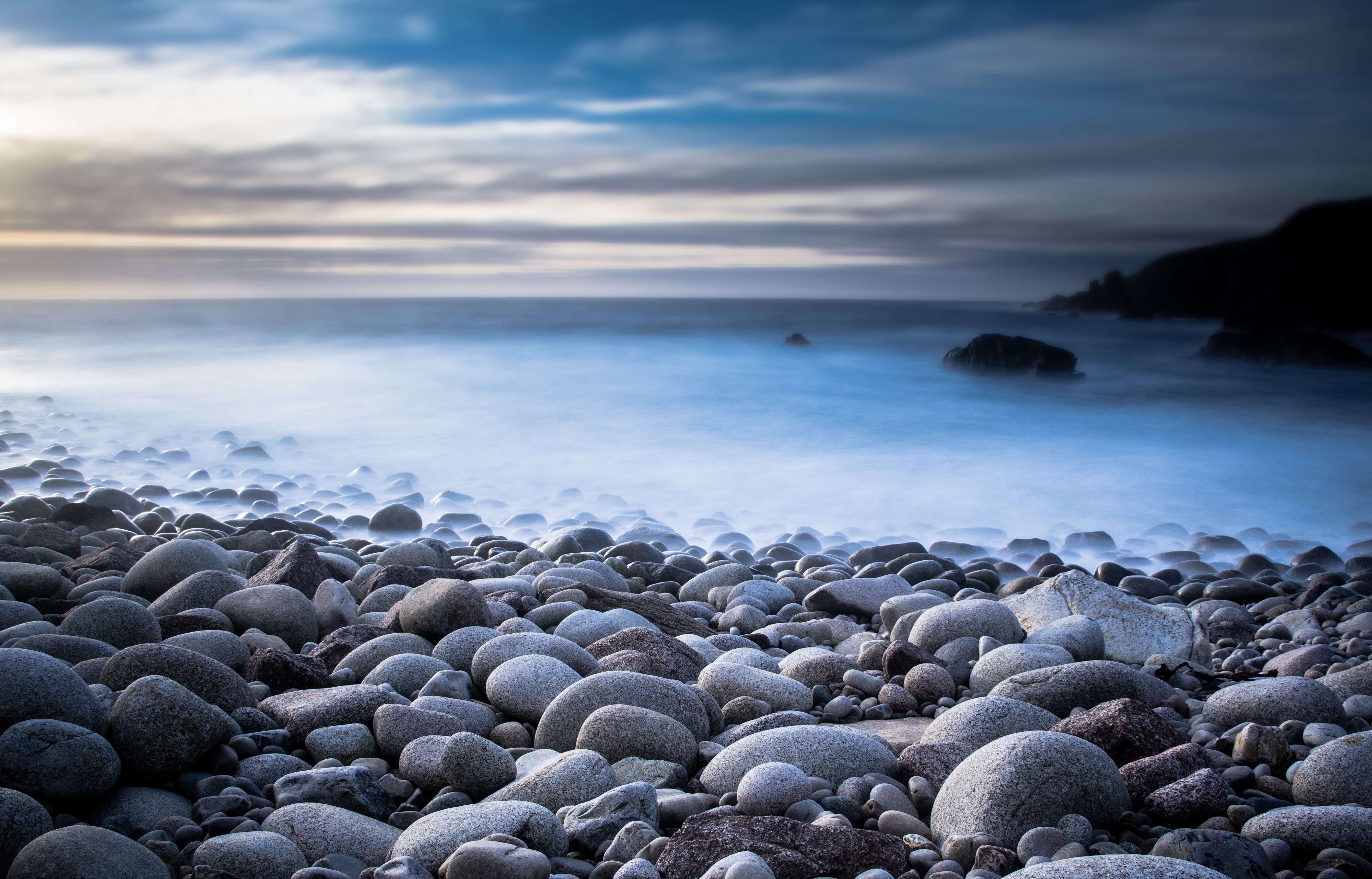 Stones on a rocky coast with ocean waves HD Wallpaper