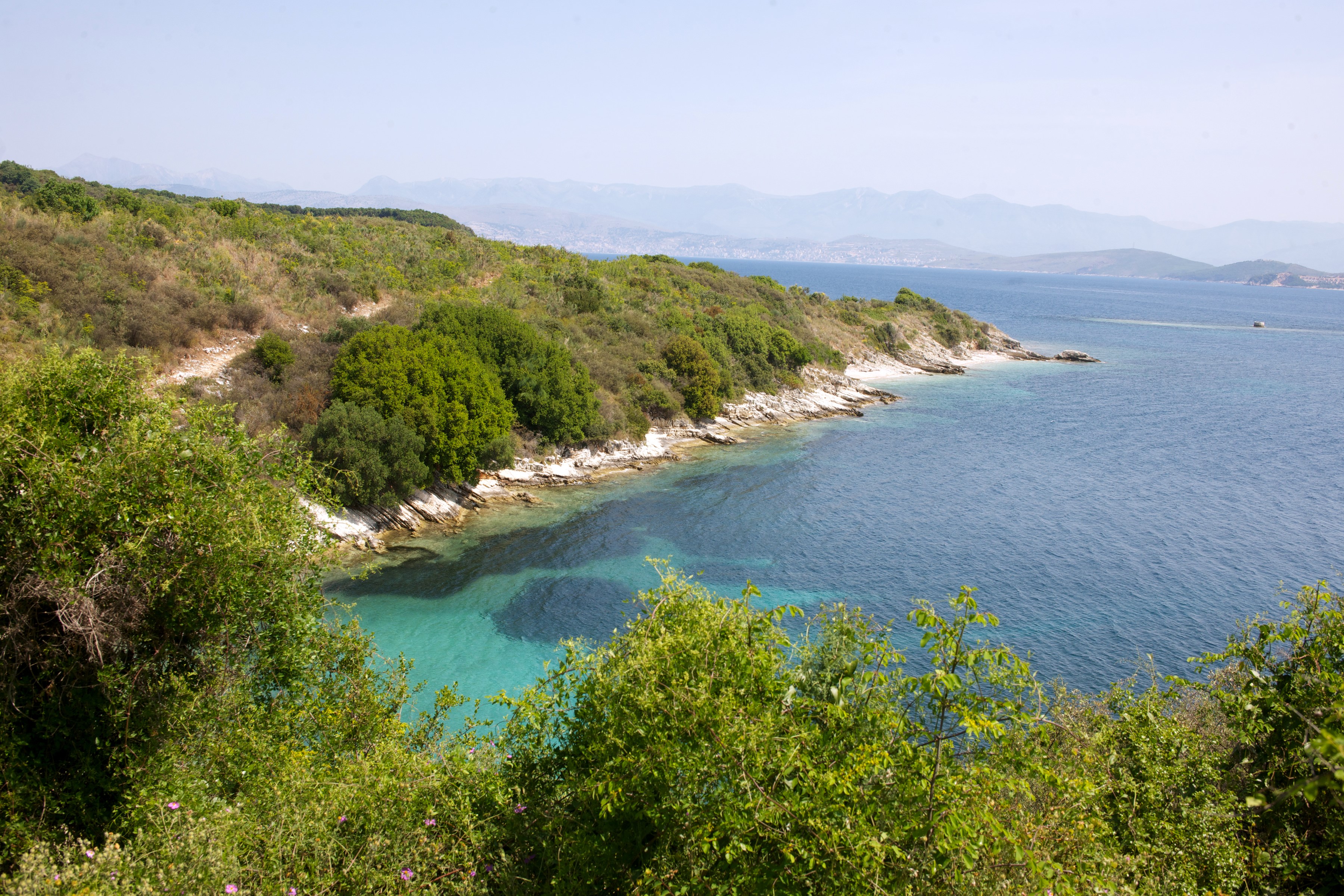 Coastal landscape with turquoise water and green hills HD Wallpaper