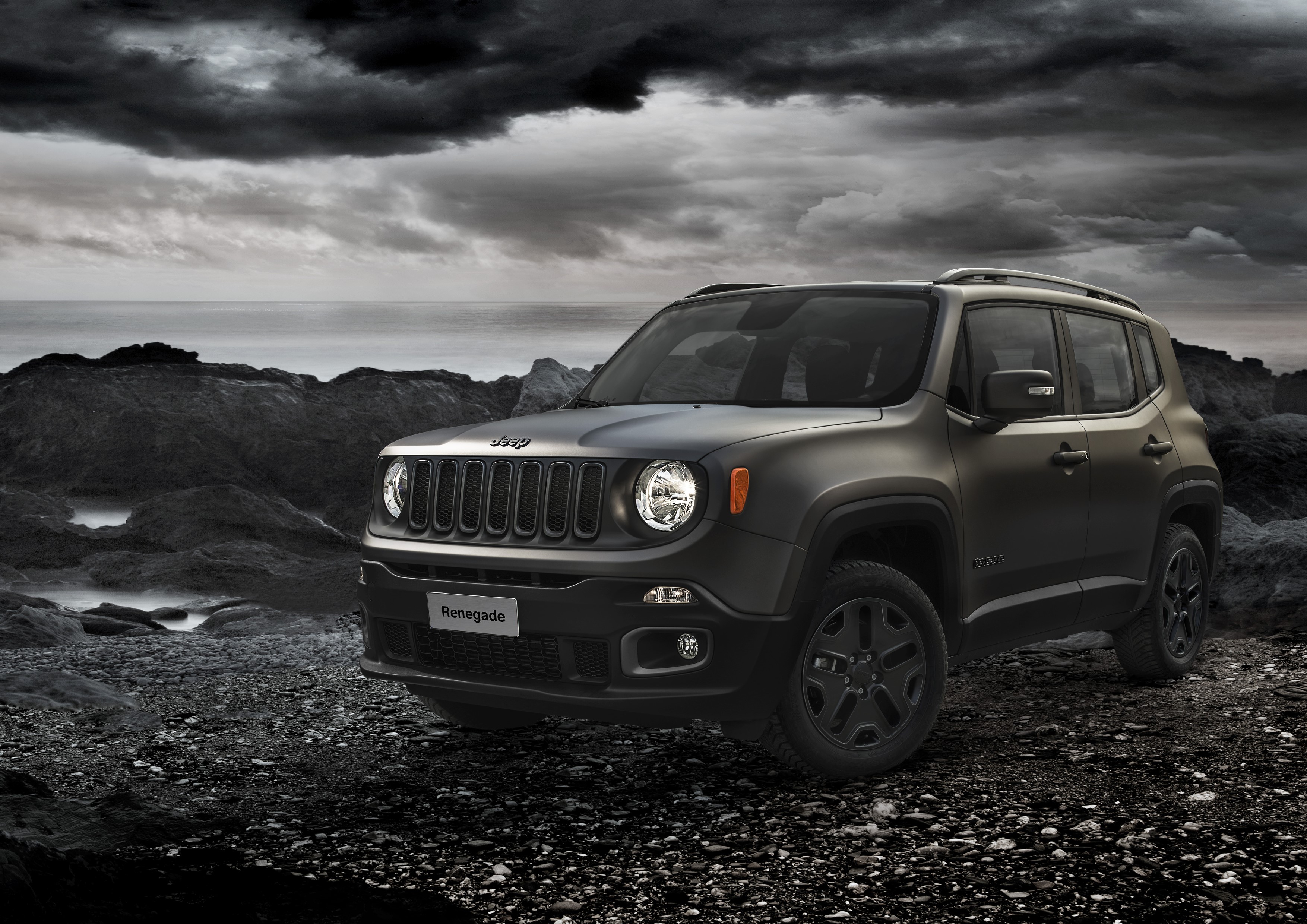 Jeep Renegade parked on rocky terrain near the ocean HD Wallpaper