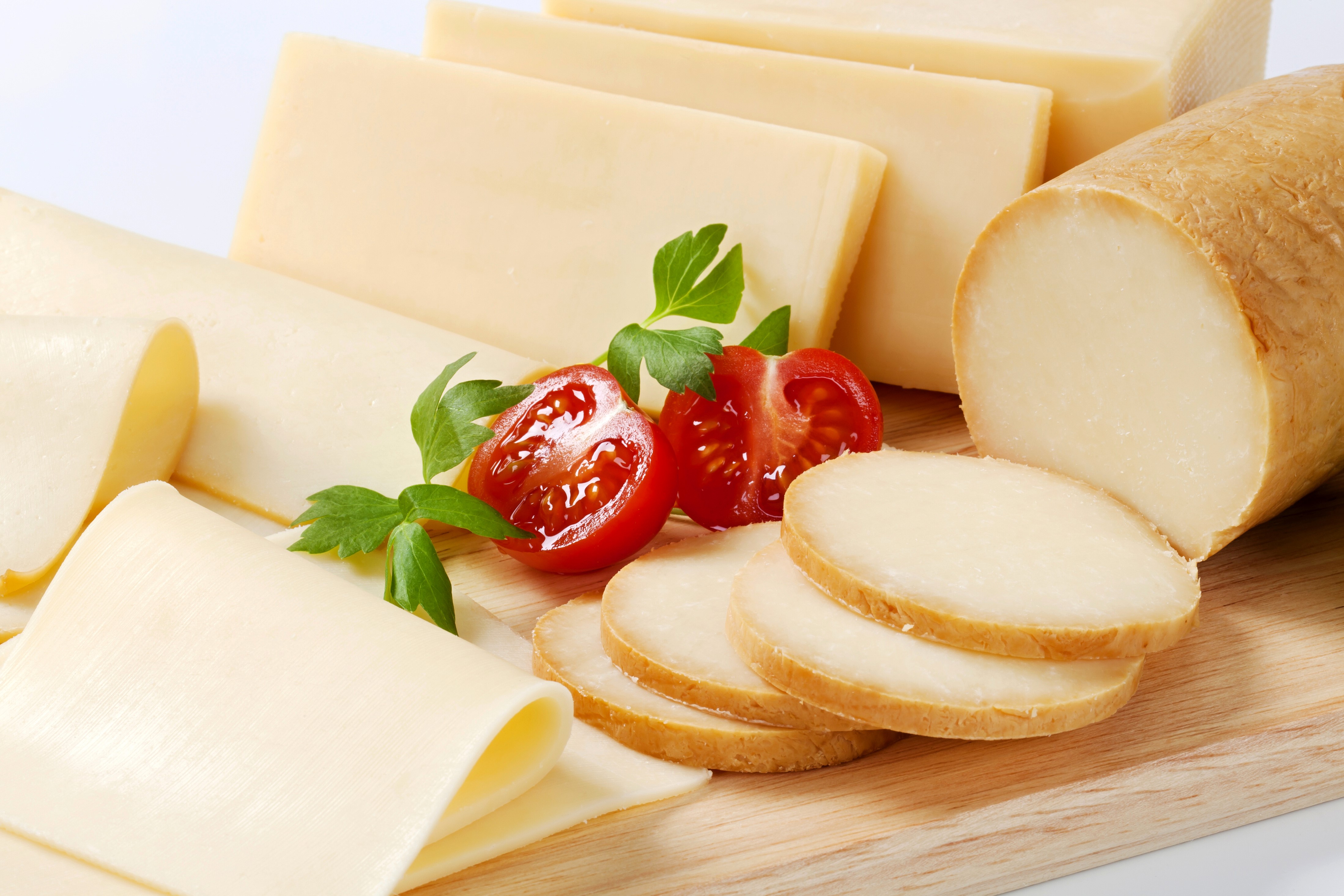 Cheese slices and tomatoes on a wooden board HD Wallpaper