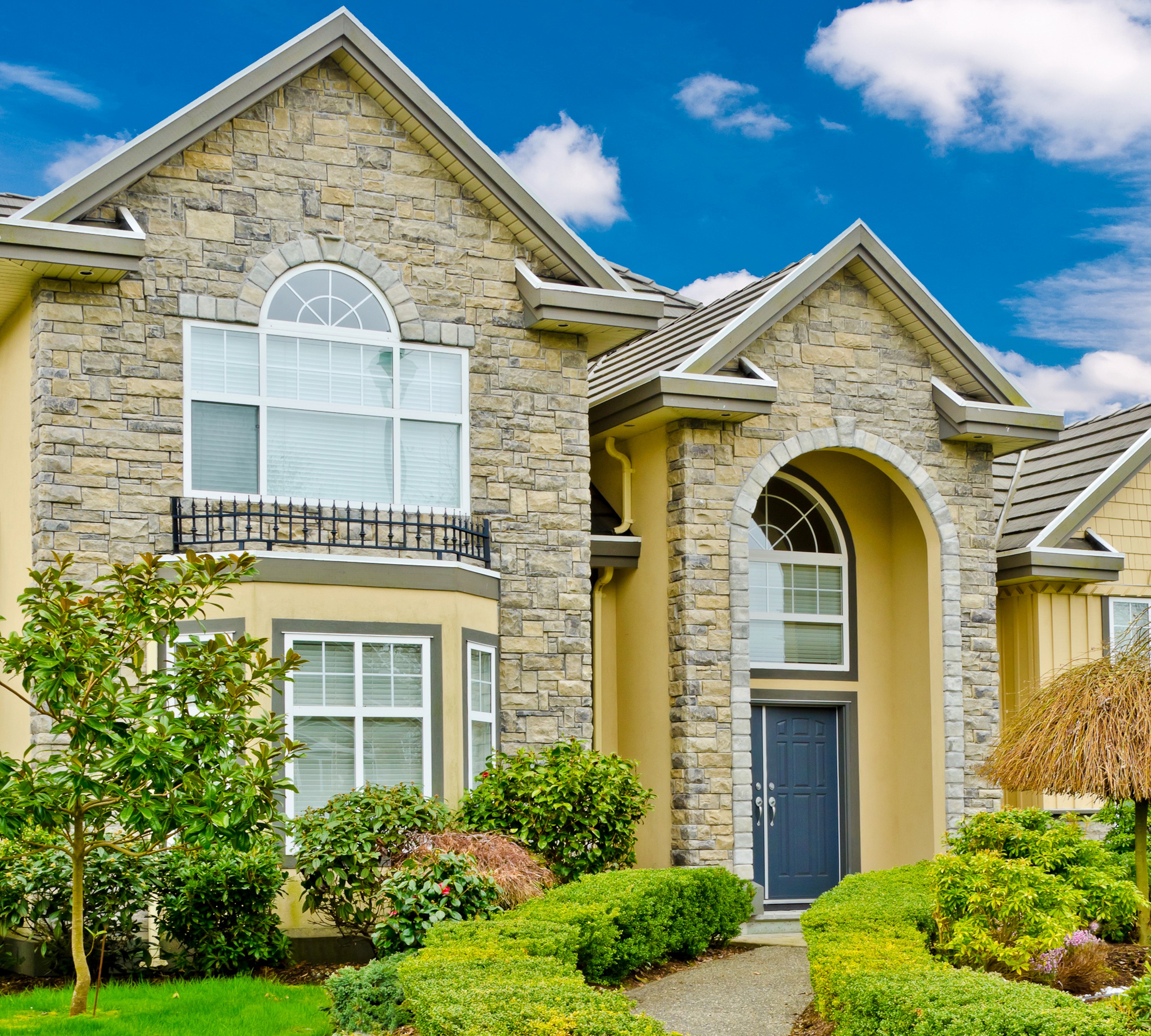 Luxury house with stone facade and manicured garden HD Wallpaper