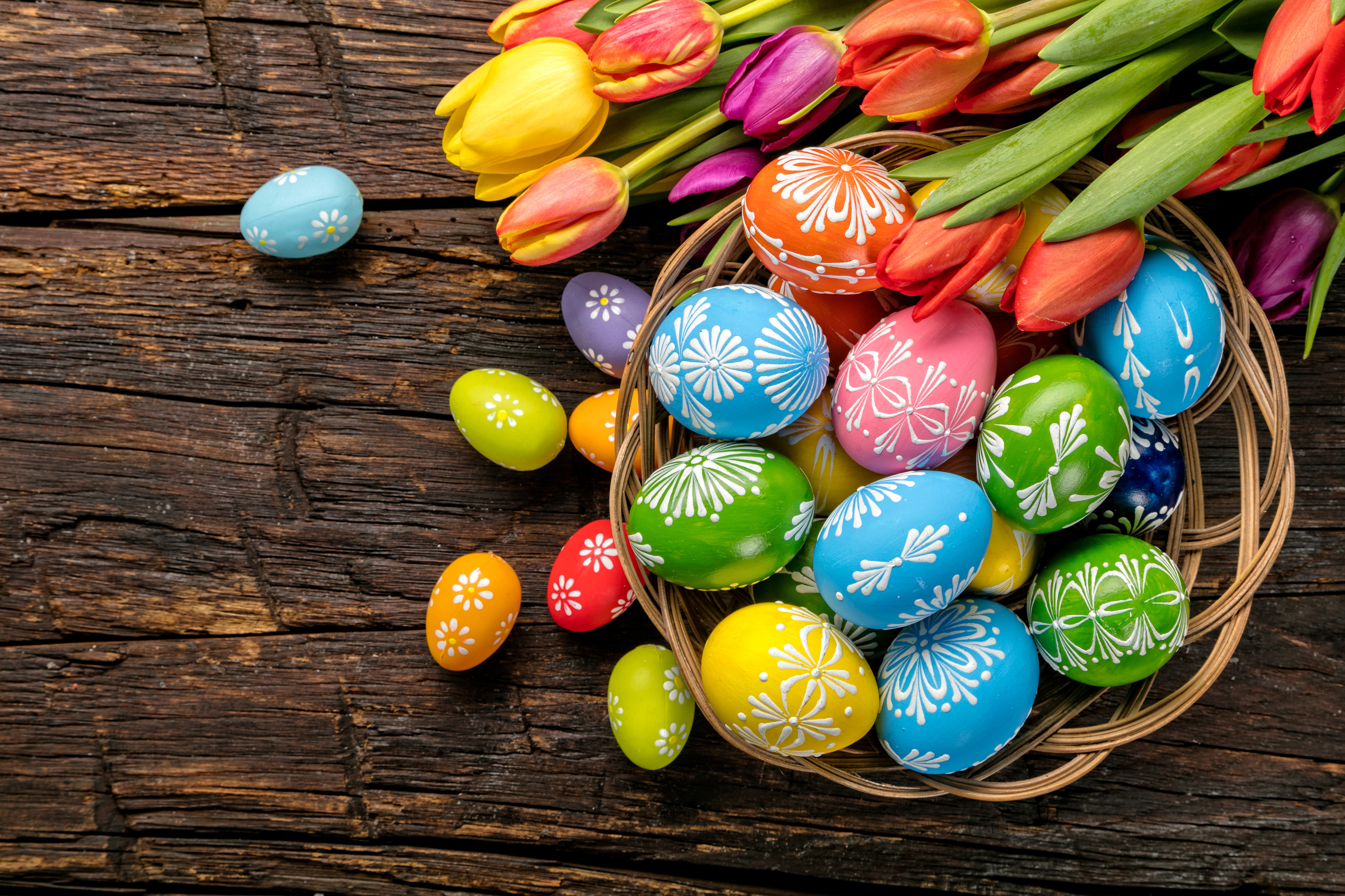 Easter eggs and tulips on a wooden table HD Wallpaper