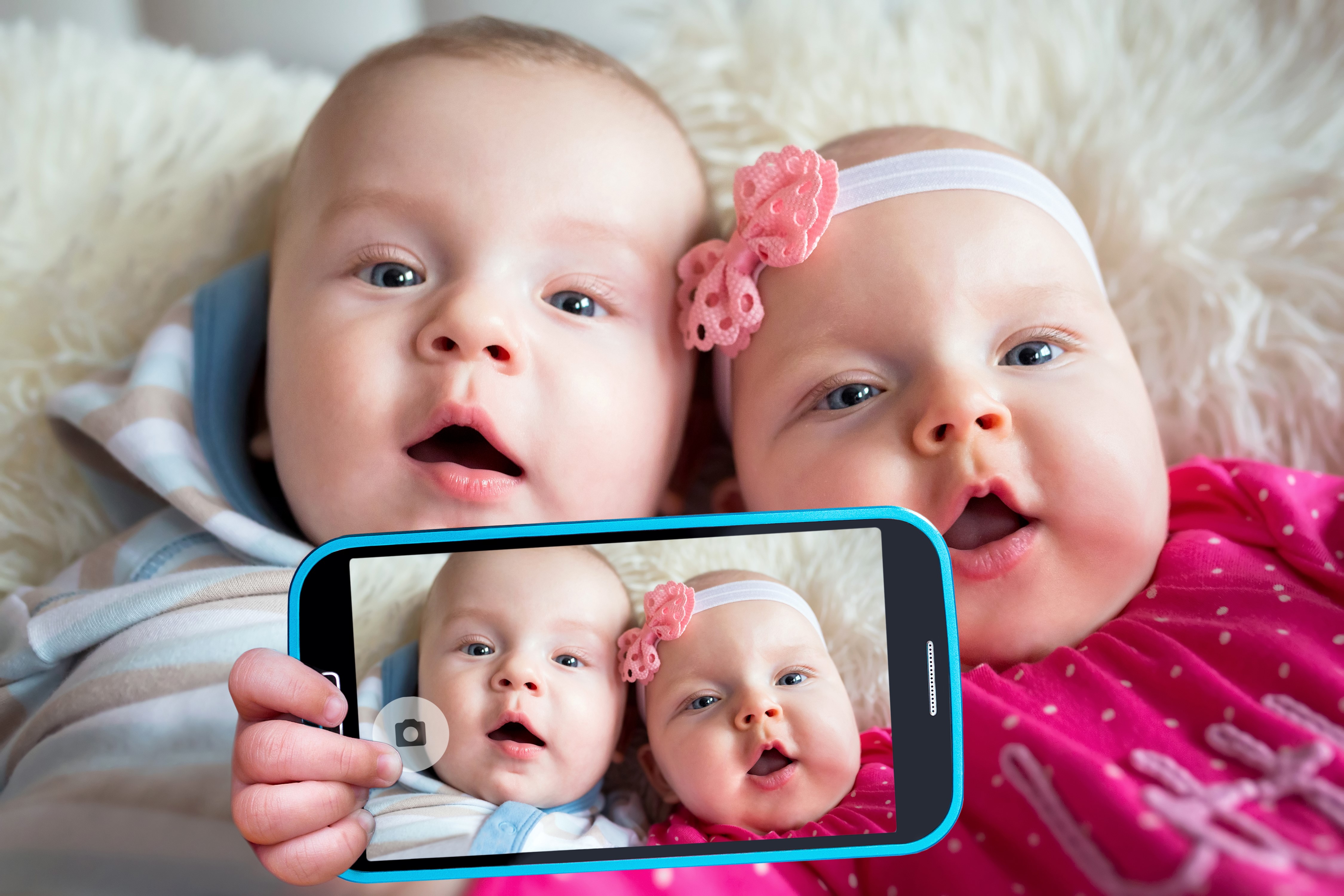 Two babies taking a selfie on a smartphone HD Wallpaper