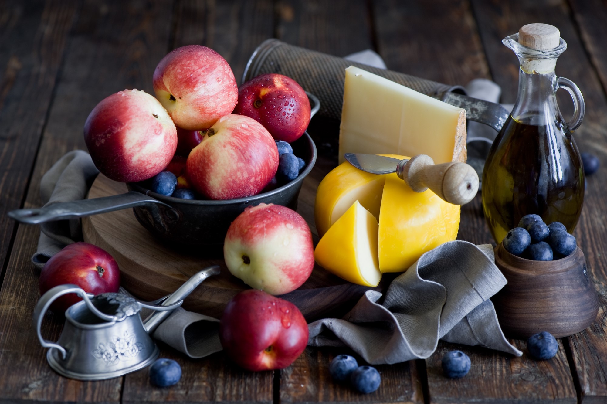 Nectarines, blueberries, cheese, and olive oil on a wooden table HD Wallpaper