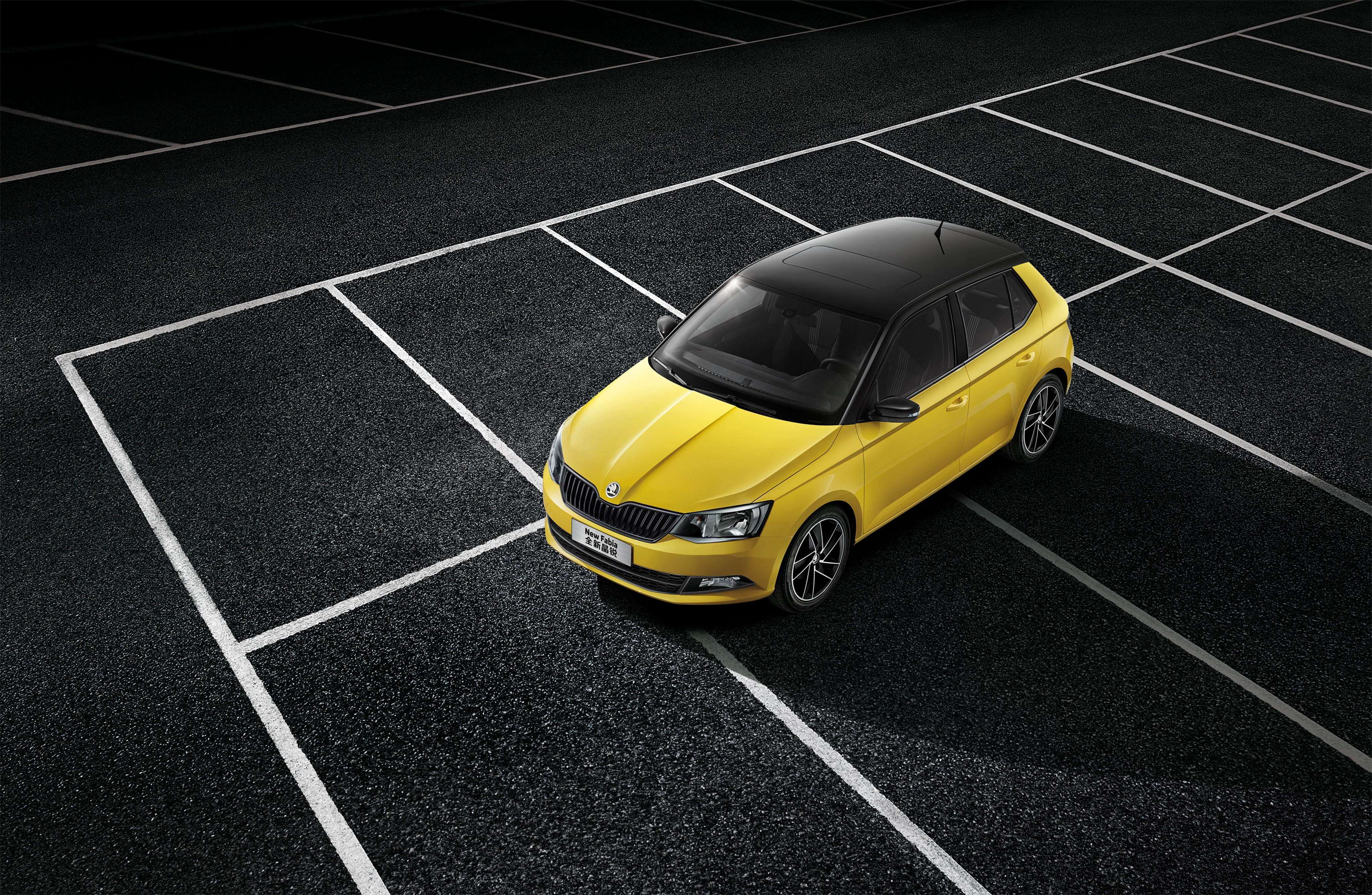 Yellow Skoda Fabia parked on asphalt with white lines HD Wallpaper