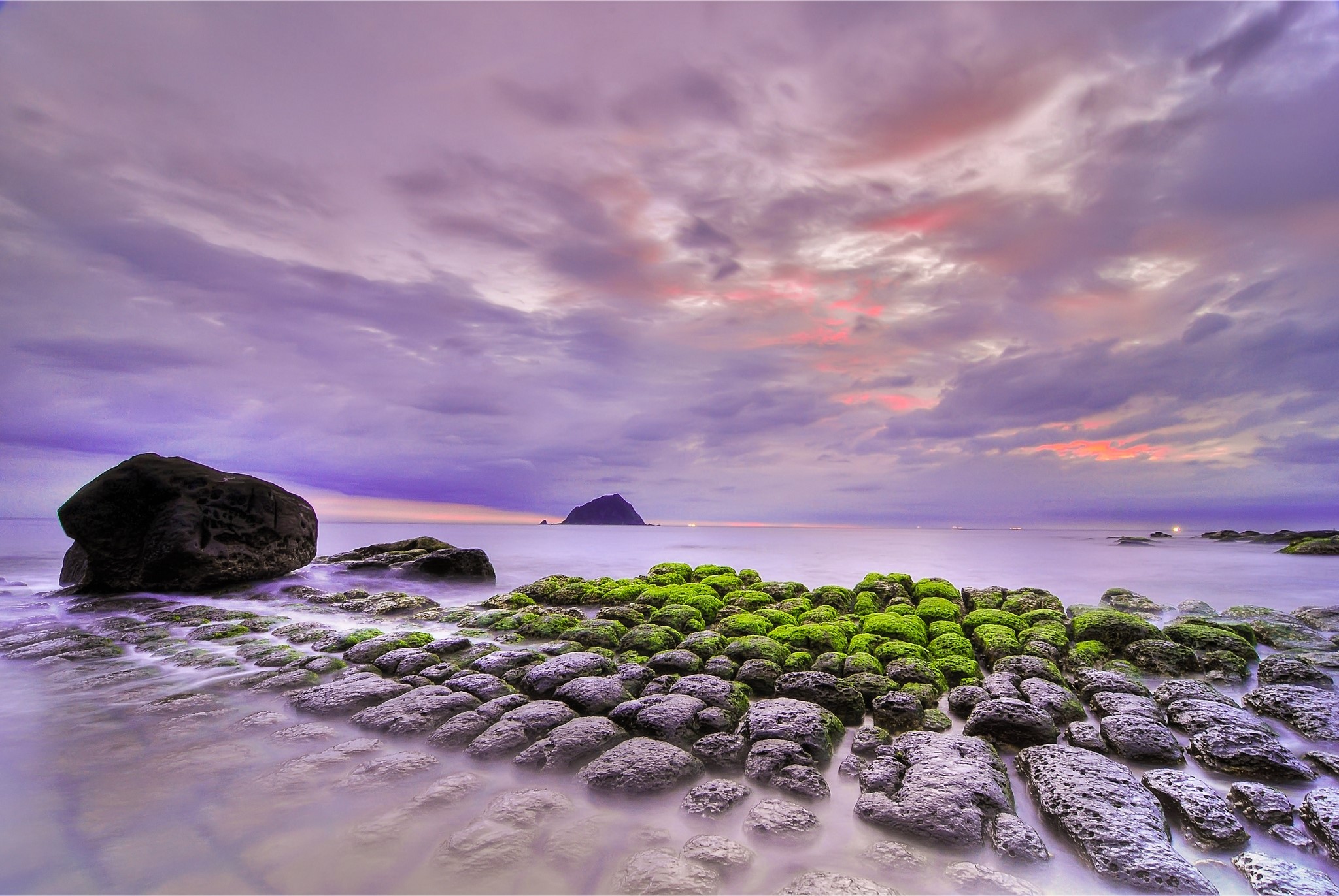 Rocky Coastline with Mossy Stones and Island at Sunset HD Wallpaper