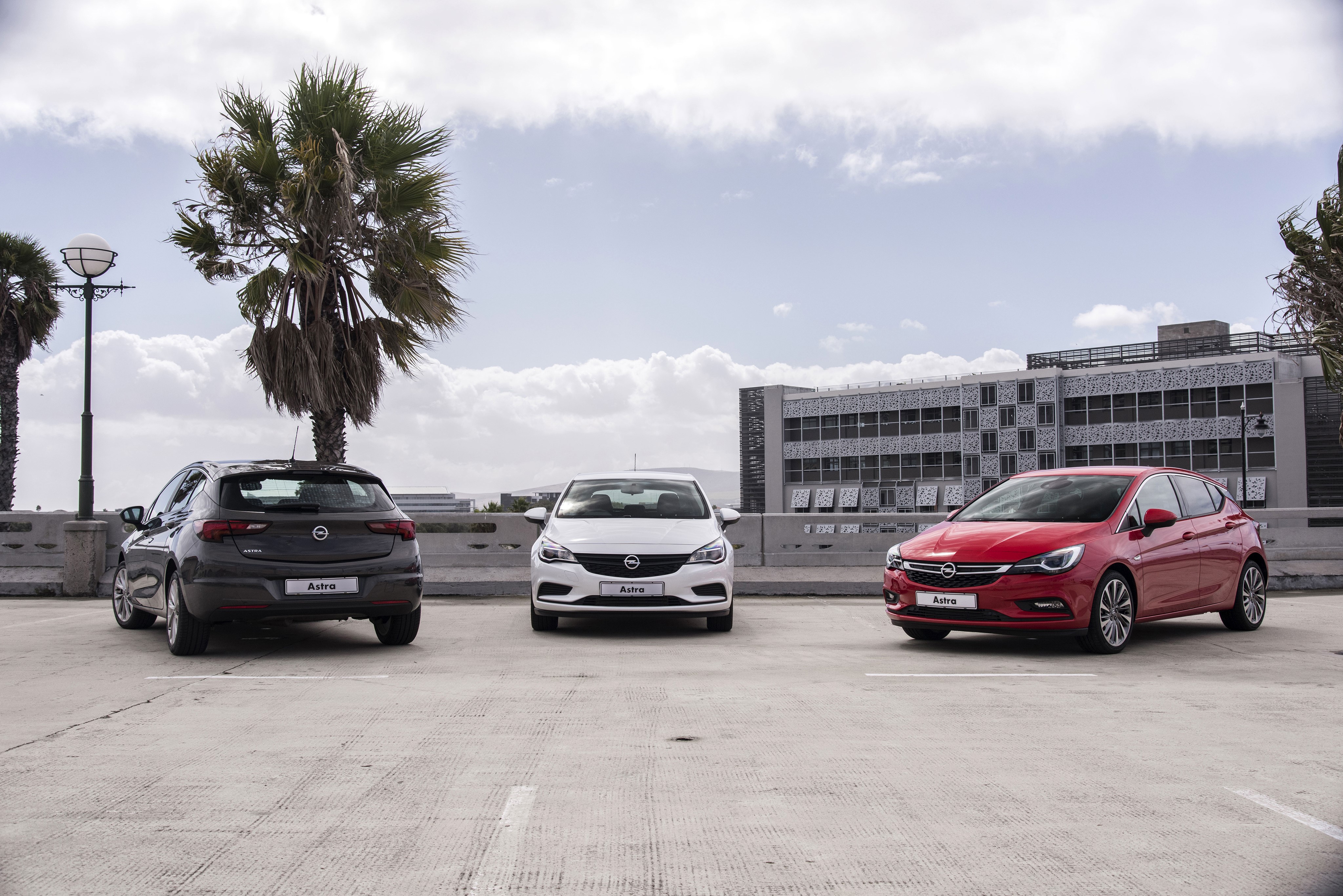 Three Opel Astra cars parked in a lot HD Wallpaper