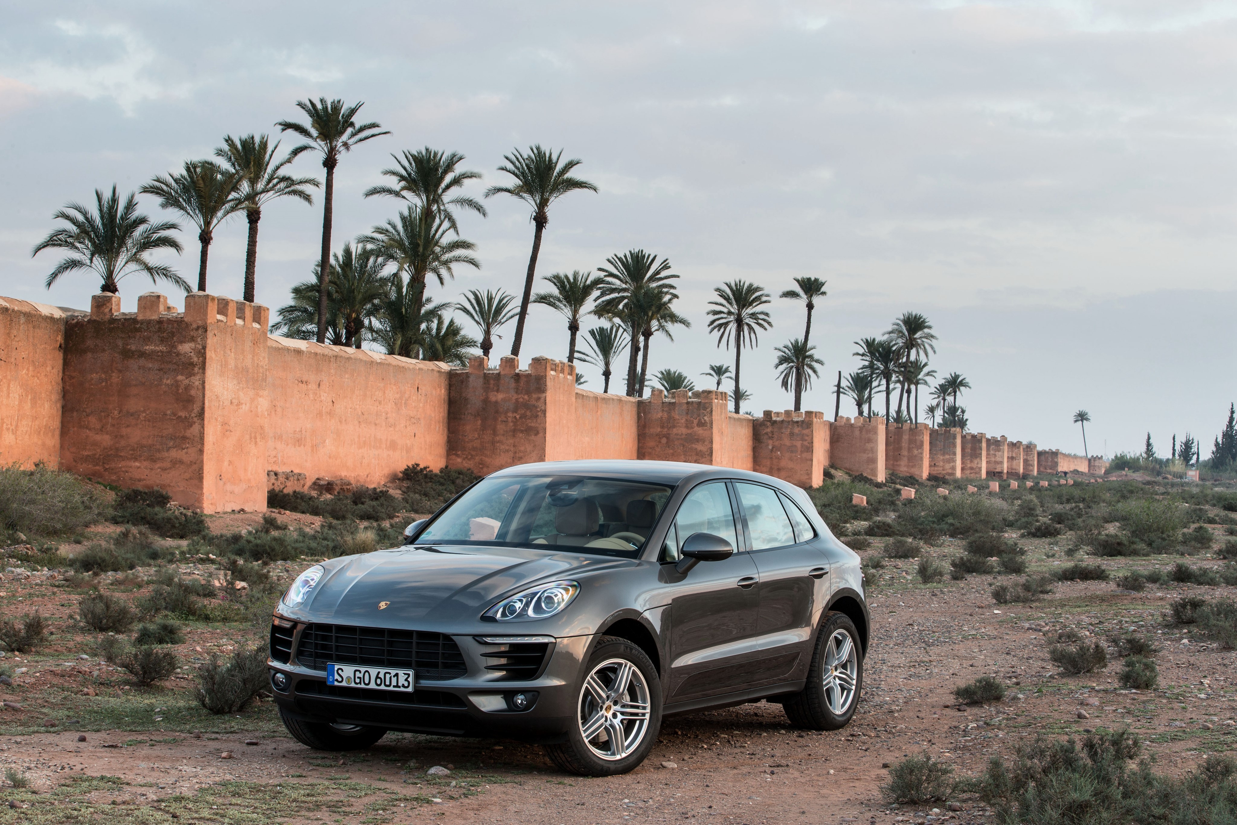 Porsche Macan S in front of a wall with palm trees HD Wallpaper