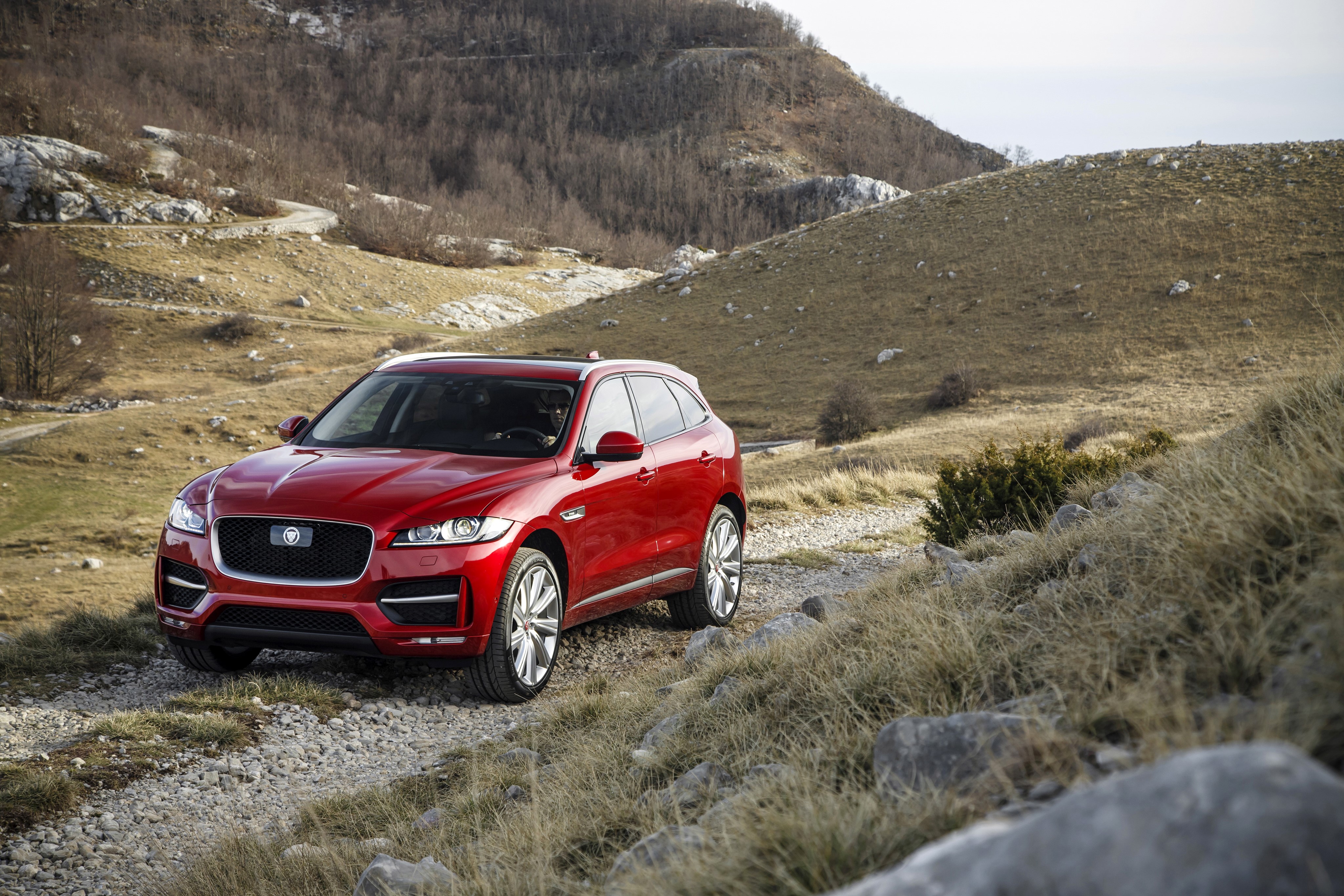 Red 2016 Jaguar F-Pace R-Sport on a dirt road HD Wallpaper