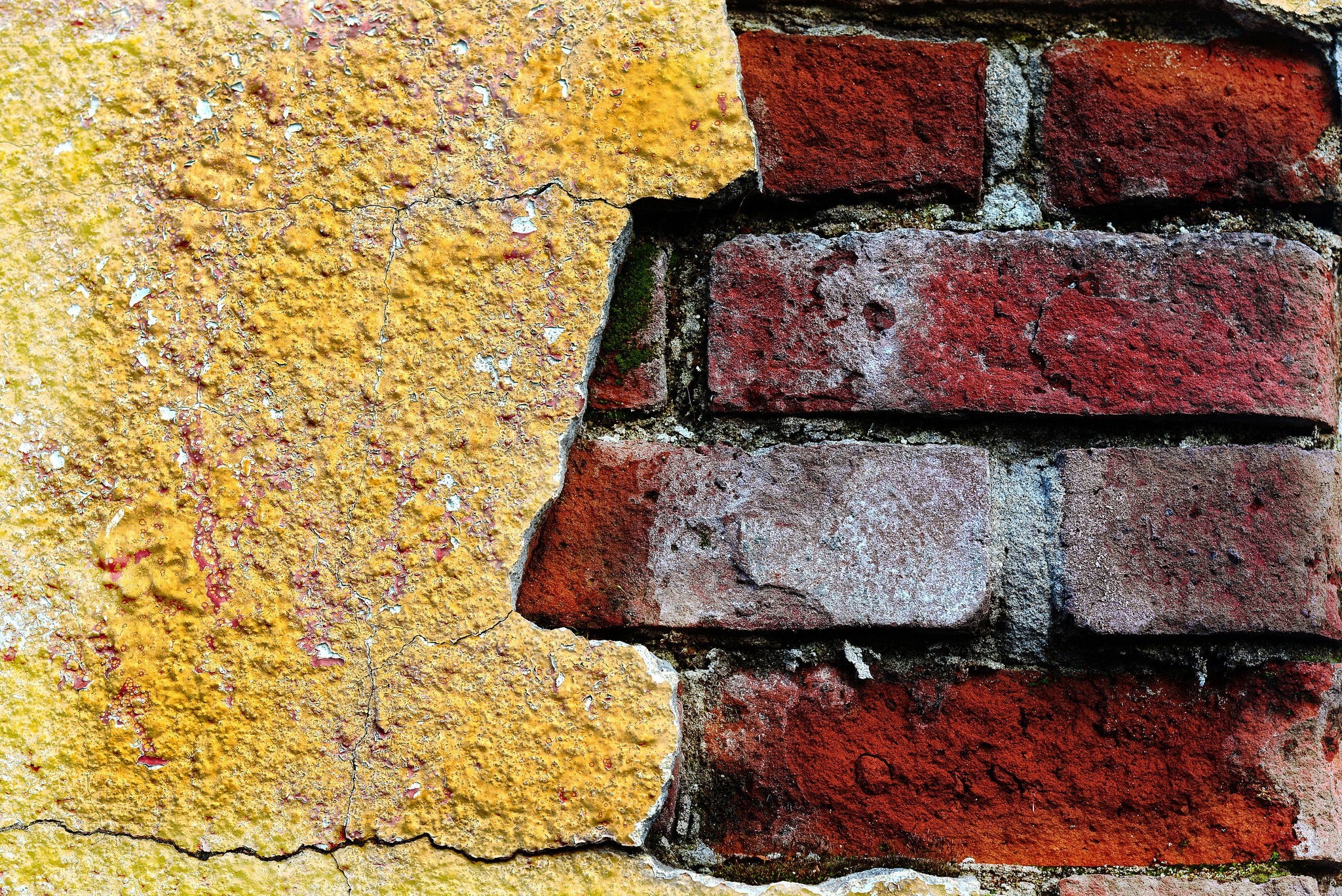 Cracked yellow plaster on a red brick wall texture HD Wallpaper